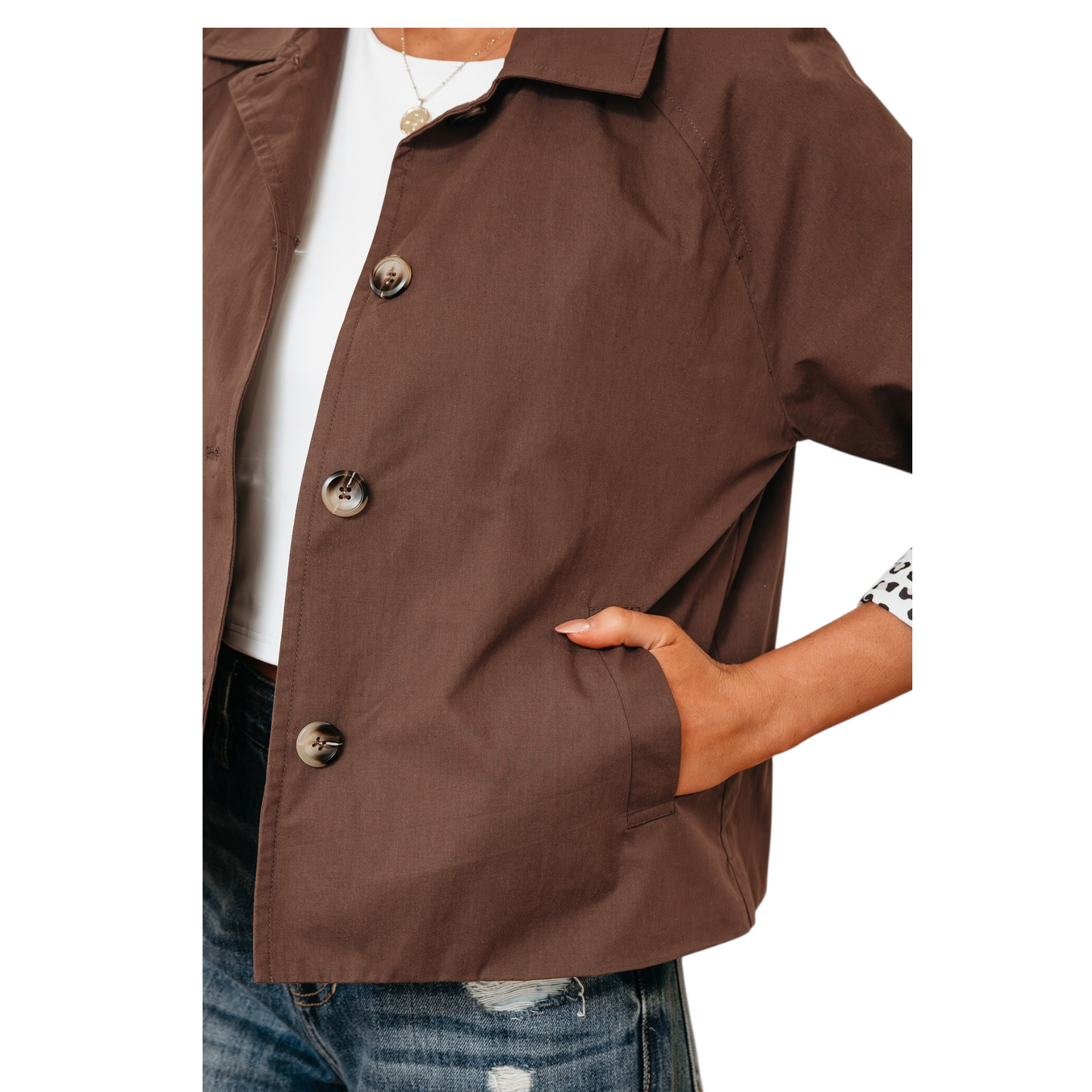 A close-up detail shot of the jacket's interior, showcasing the bold leopard print lining patchwork against the solid brown cotton outer and button-front closure with side pockets.