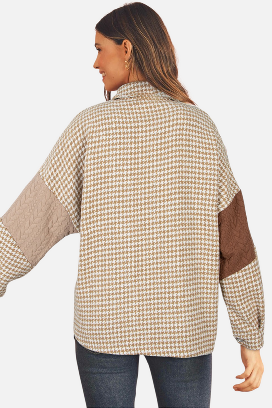A model viewed from the back, displaying the distinctive brown patchwork shacket with a mix of houndstooth pattern and different-coloured cable-knit sleeves.