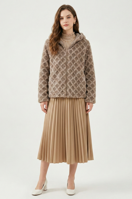 Woman wearing a patterned jacket and beige pleated skirt on a white background