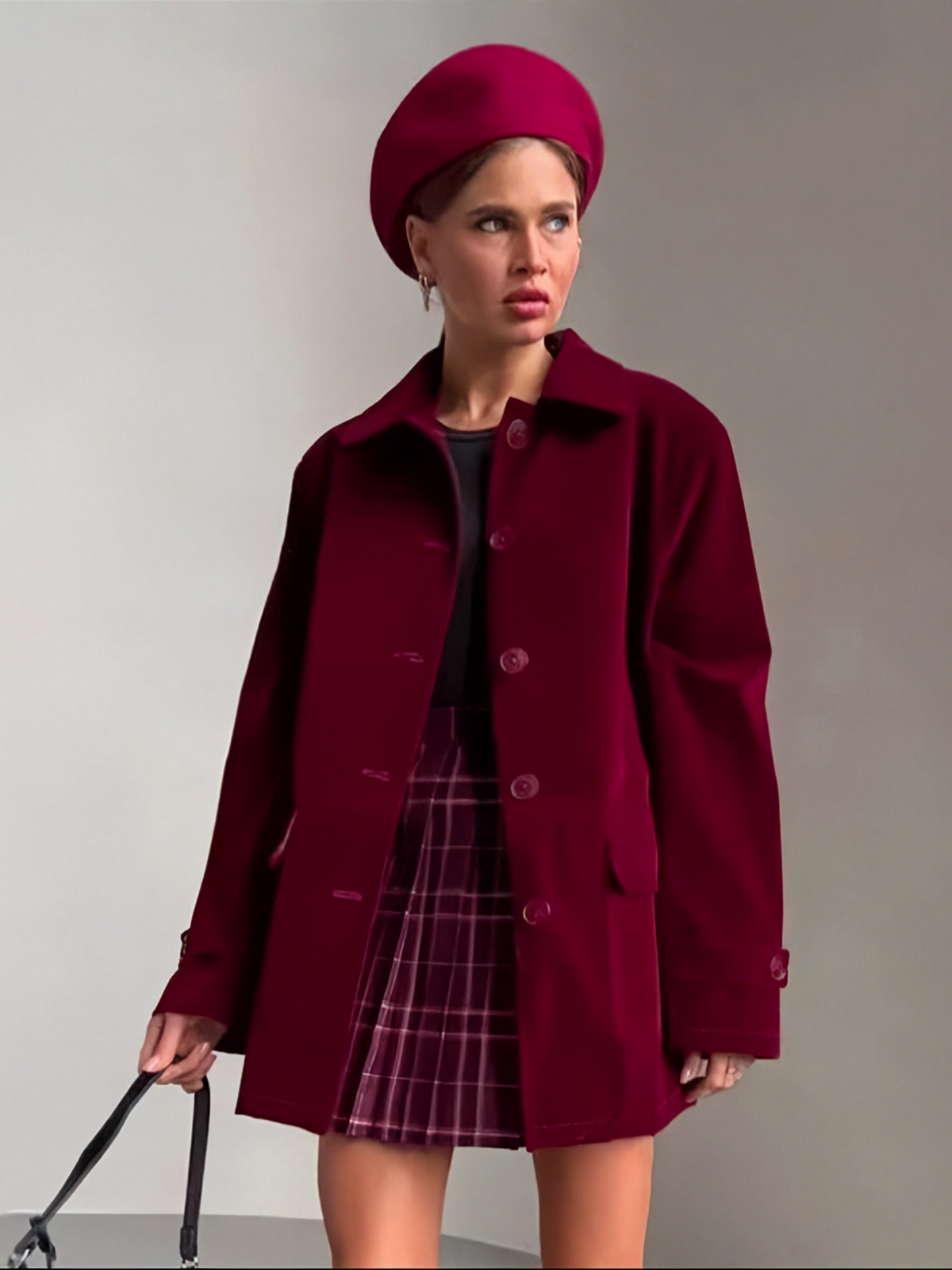 Model wearing a Catherine Martin burgundy oversized velvet jacket with a matching beret and plaid skirt
