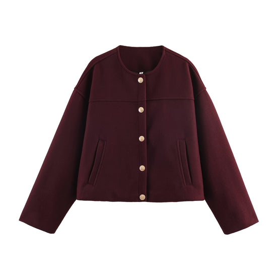 Front view of a burgundy cropped jacket with a round neck, two side welt pockets, and five ornamental gold crest buttons.