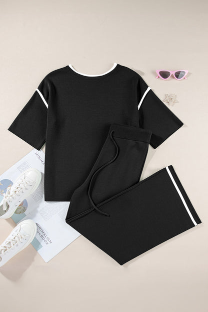 Black outfit with white accents on a beige surface