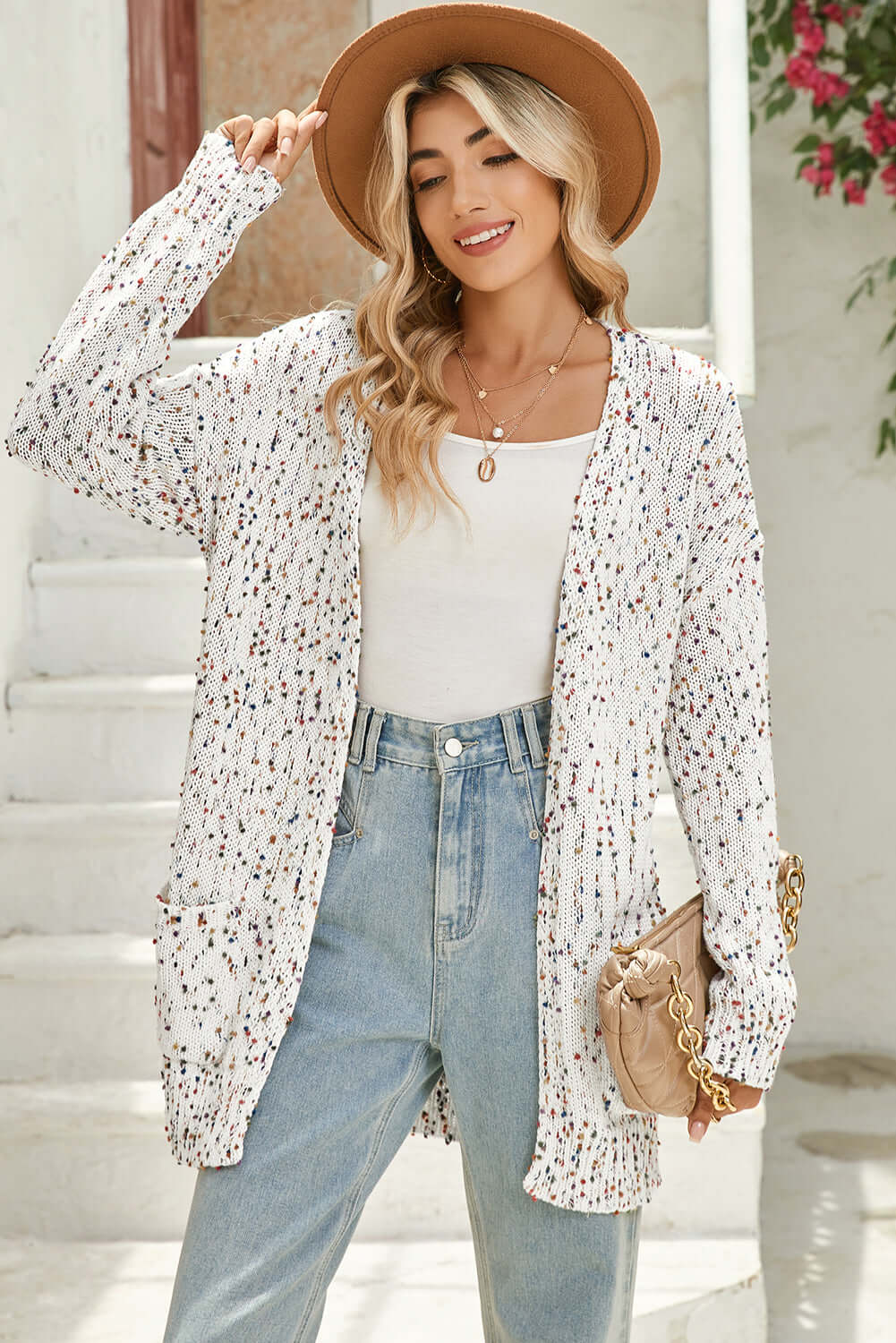 Woman wearing a white dot longline cardigan, styled with casual jeans and a top.