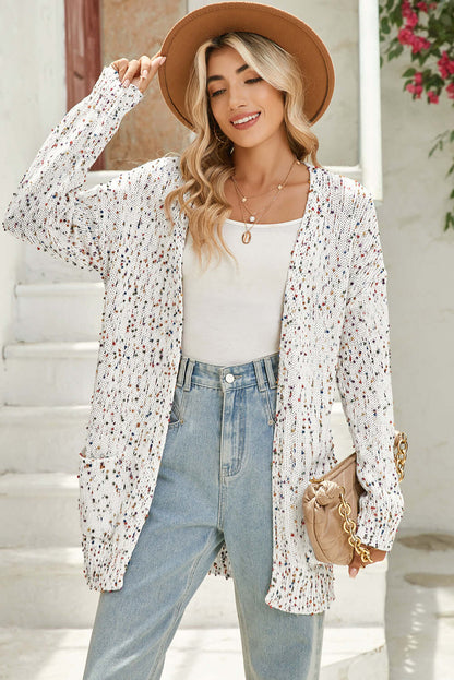 Woman wearing a white dot longline cardigan, styled with casual jeans and a top.