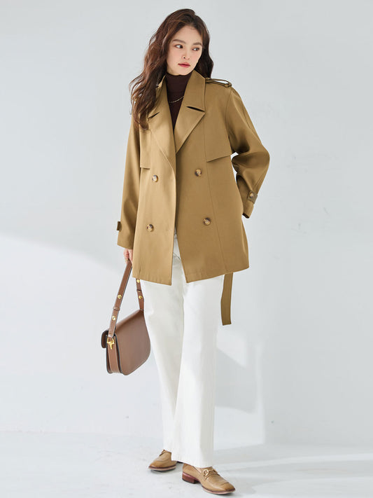 Woman wearing a beige trench coat on a white background