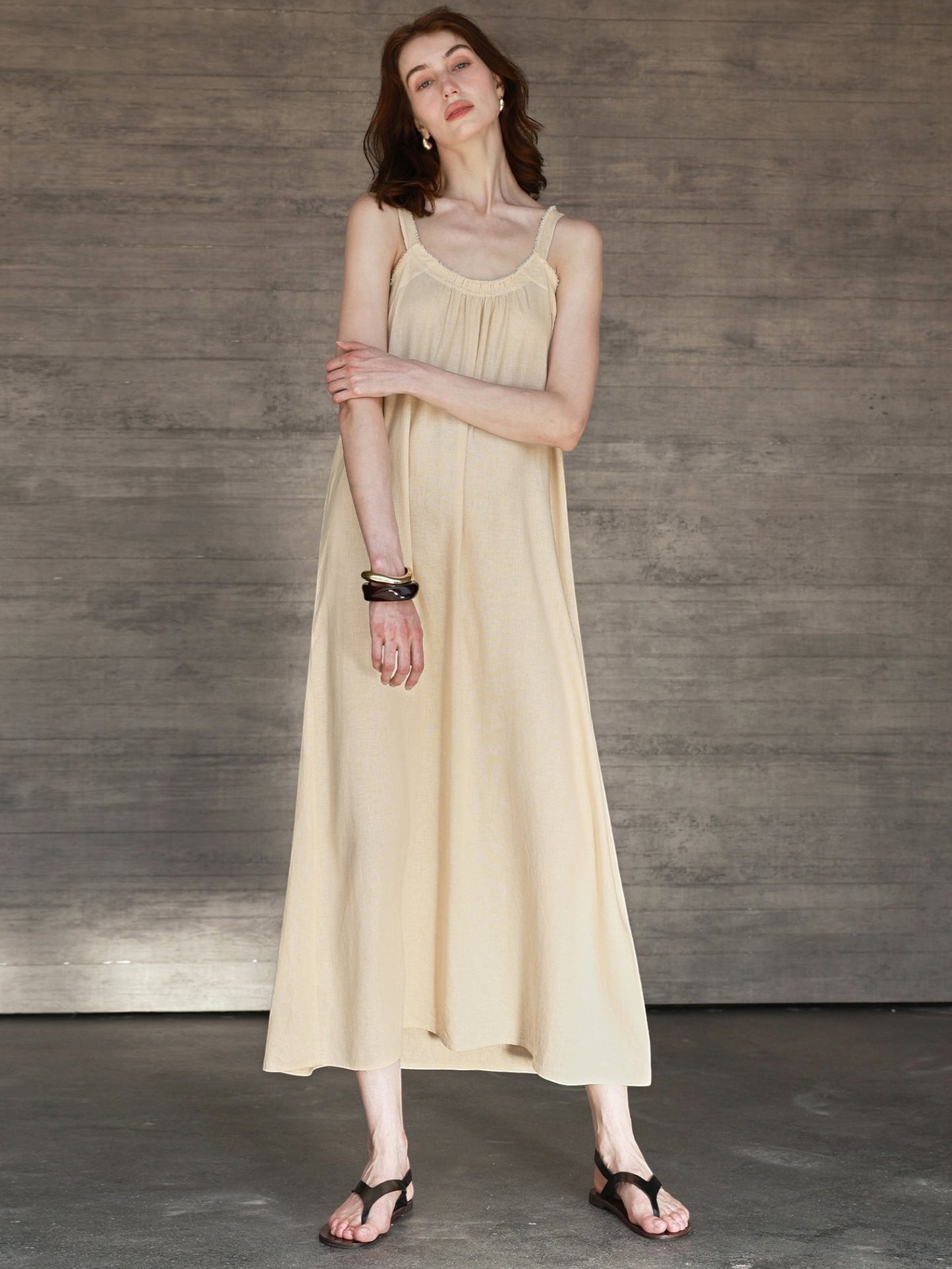 Catherine Martin beige linen and cotton maxi dress with a scoop neckline and frayed edges worn by a model