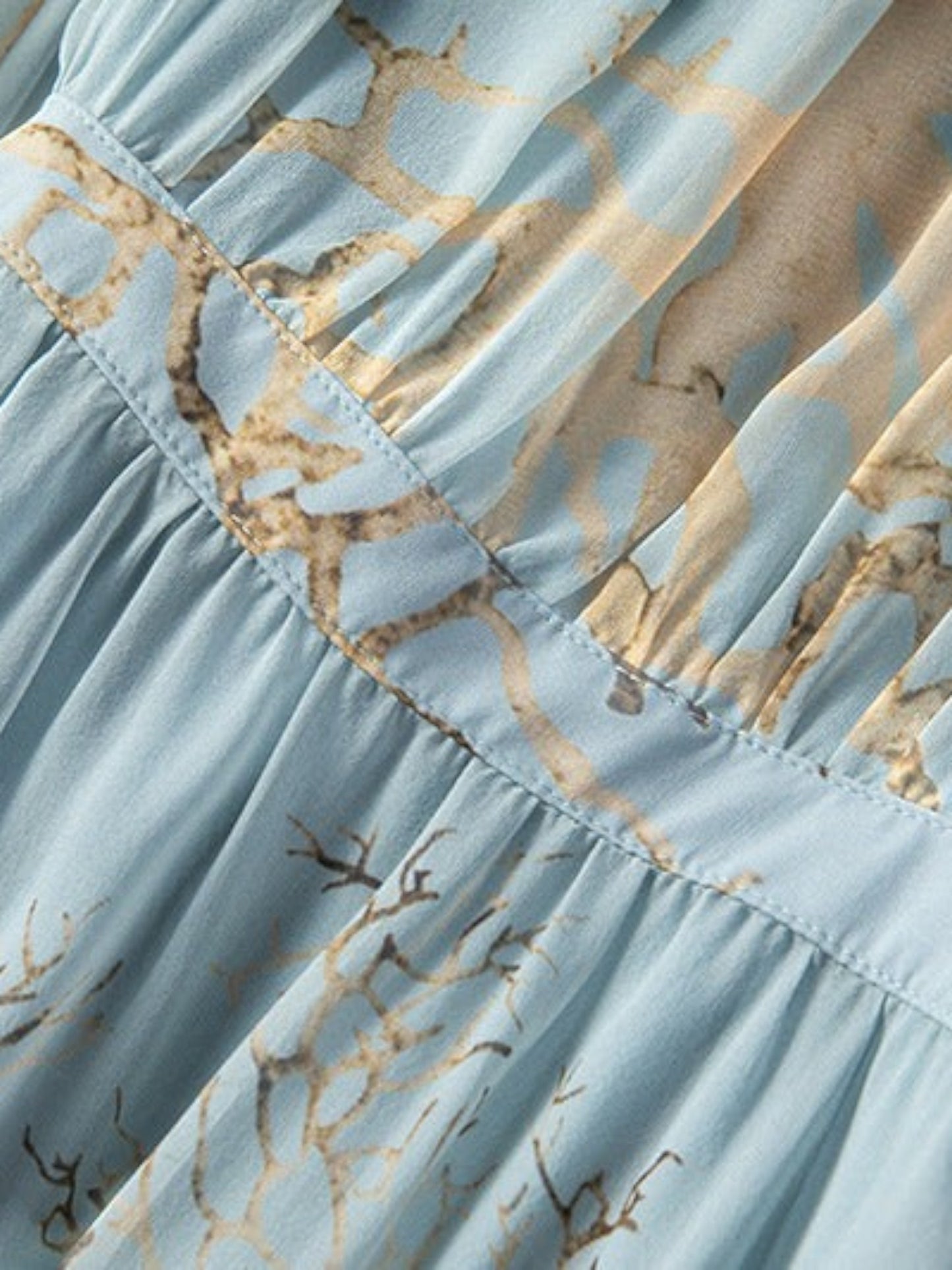 Catherine Martin silk midi dress in powder blue with a gold and brown branch print and pleated waist detail.