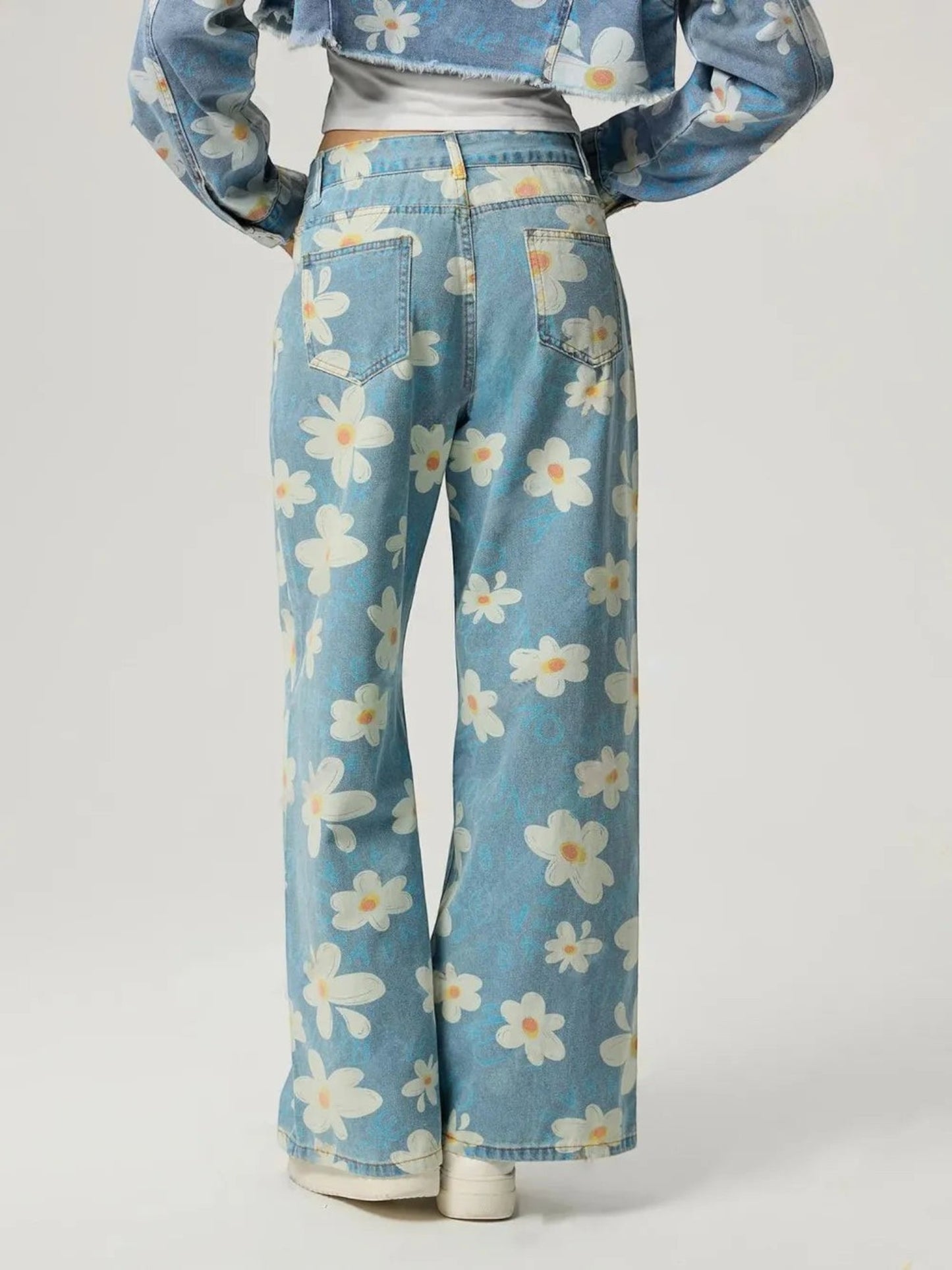 Catherine Martin wide-leg denim jeans featuring a playful cream and blue daisy print, back view with pockets.