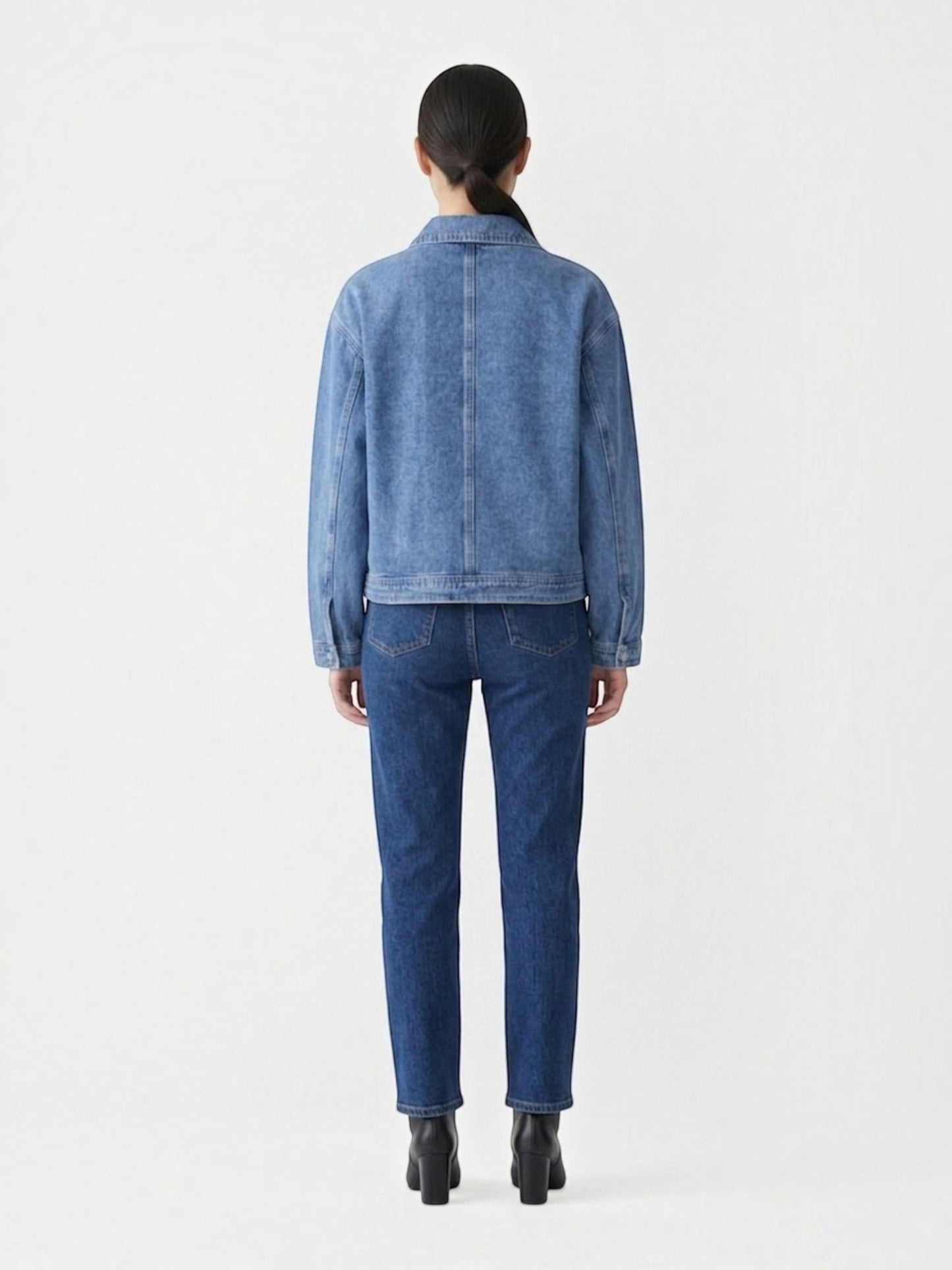 Back view of a Catherine Martin light-wash denim jacket with a relaxed silhouette and collared neckline.