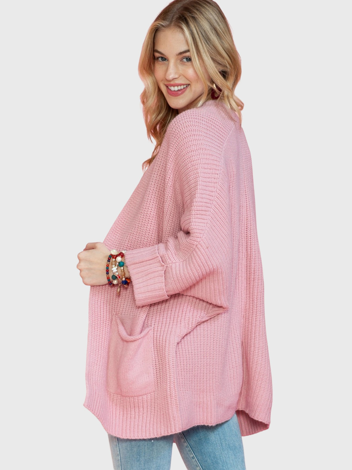 Catherine Martin dusty pink oversized knit cardigan with patch pockets and ribbed cuffs worn by a smiling blonde model