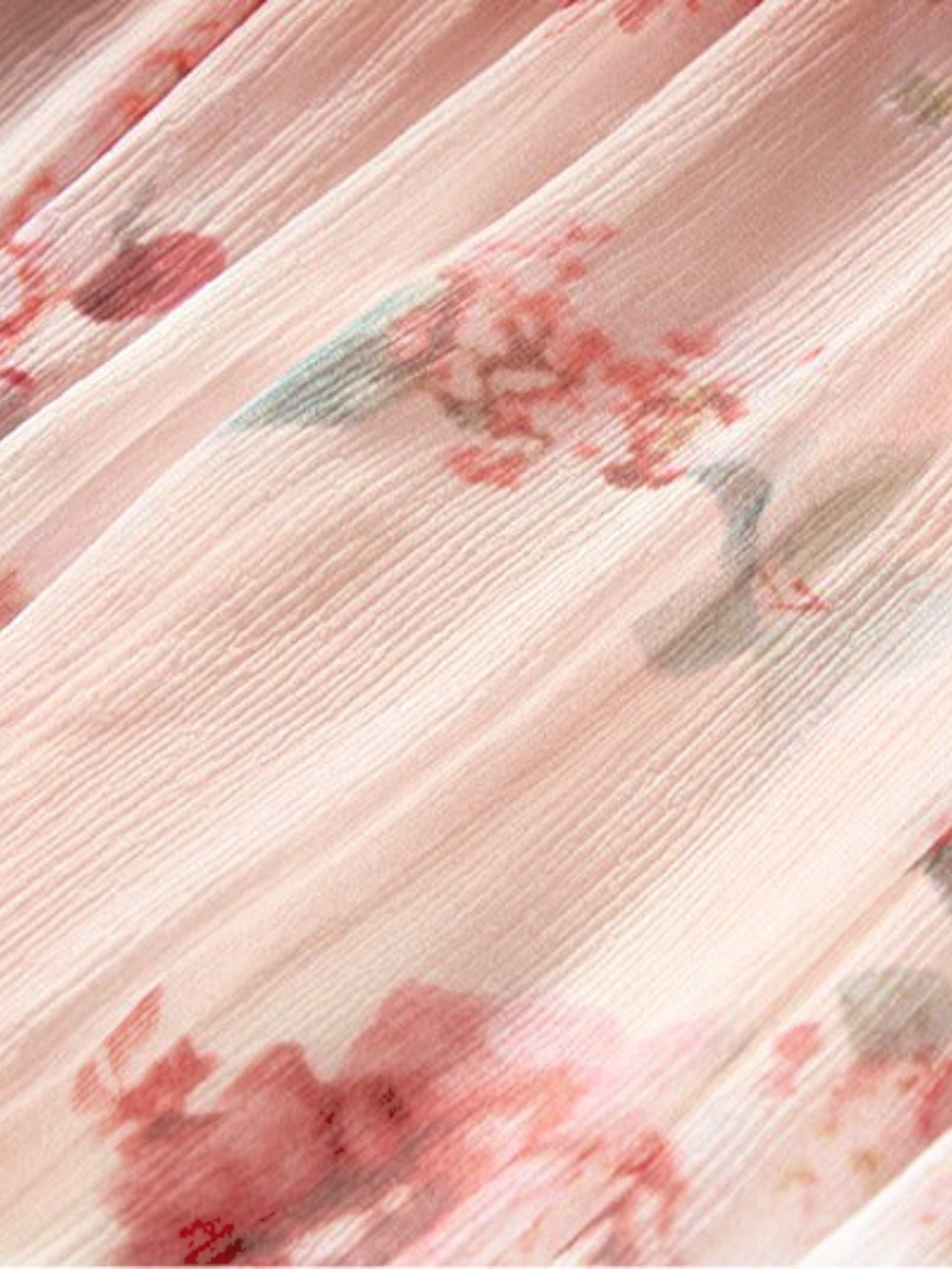 Close-up of Catherine Martin floral silk fabric with a delicate pink background and soft red and green floral print