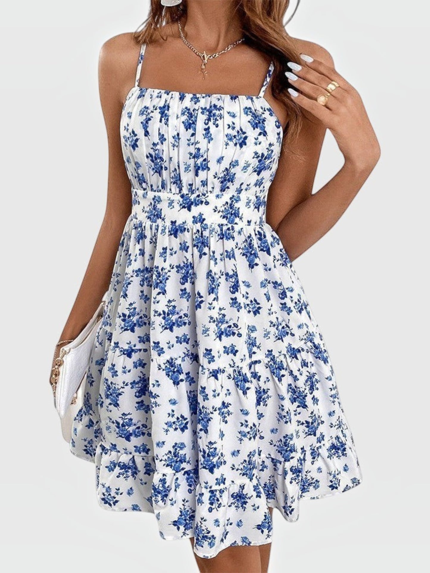 Catherine Martin blue and white floral mini dress with spaghetti straps, straight neckline, and tiered ruffle hem.
