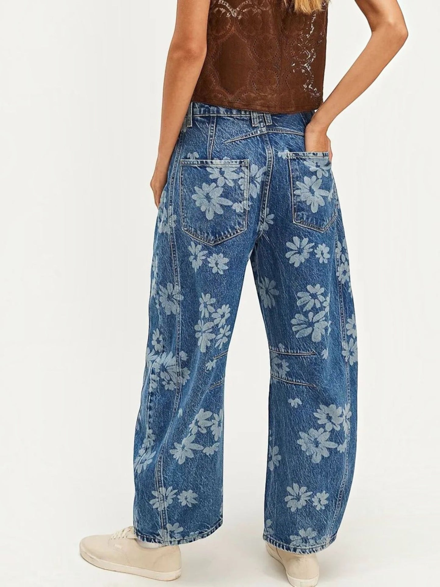 Catherine Martin wide-leg denim jeans featuring an all-over blue floral print and back pockets, worn with sneakers.