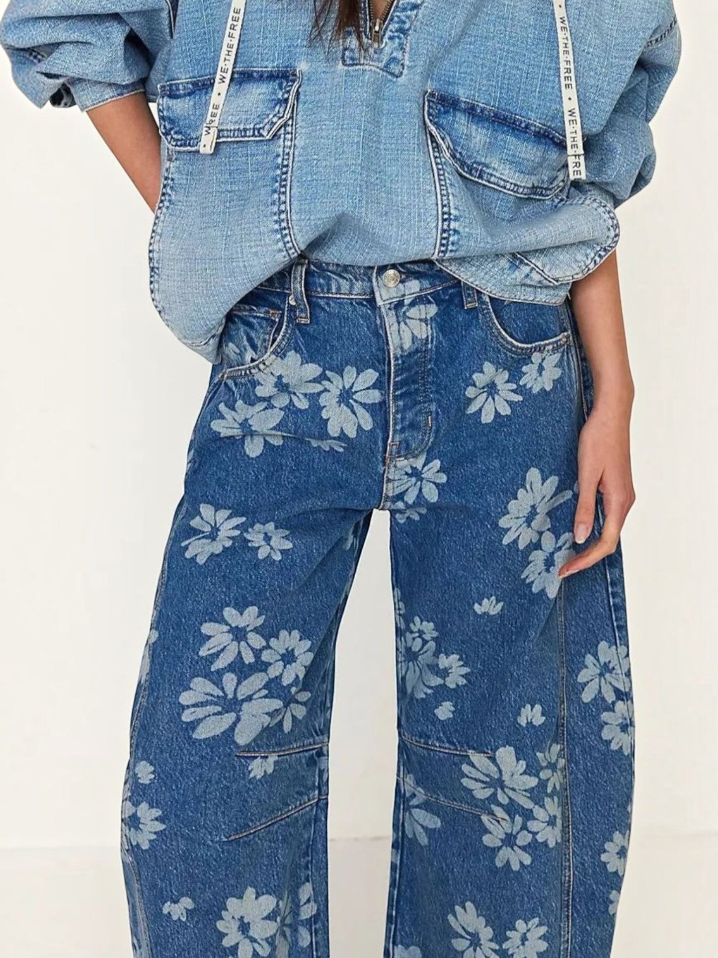 Catherine Martin blue denim wide-leg jeans featuring an all-over floral print and front pockets on a model