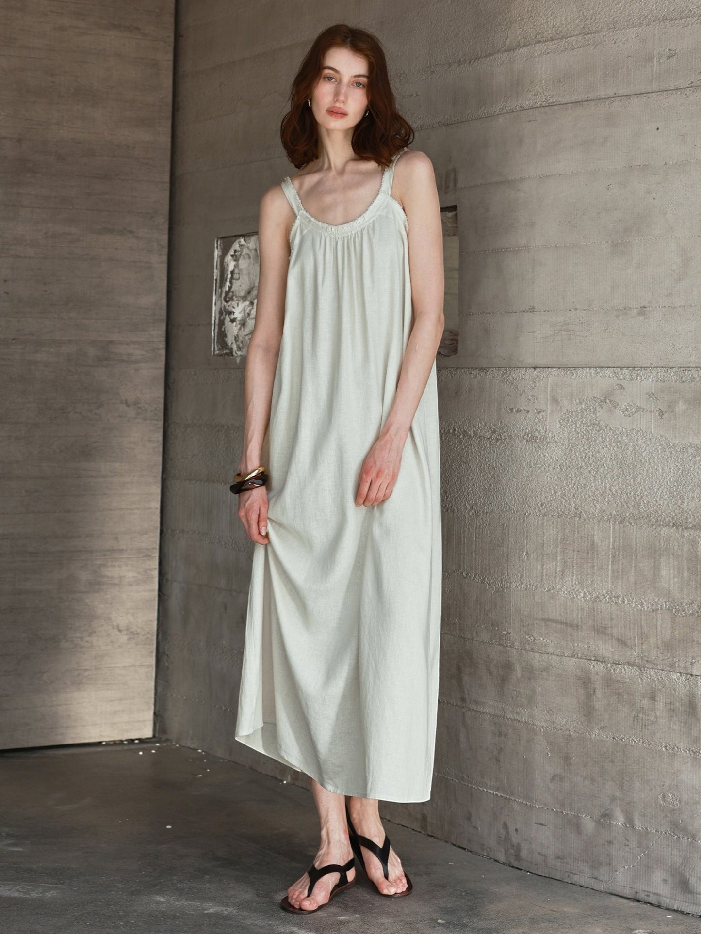 Catherine Martin linen and cotton maxi dress in sage green with frayed raw edges, scoop neckline, and flared silhouette