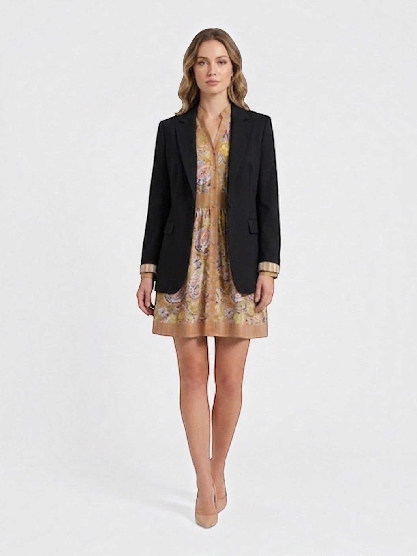 Catherine Martin paisley print mini dress layered under a black blazer worn by a model with beige heels