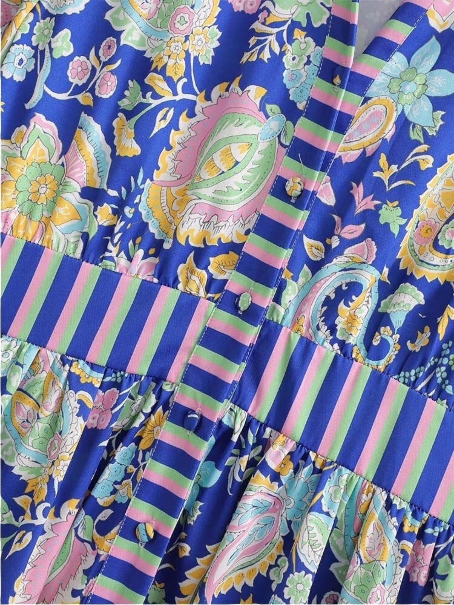 Close-up of a Catherine Martin paisley print mini dress featuring a button-front placket and striped waistband.