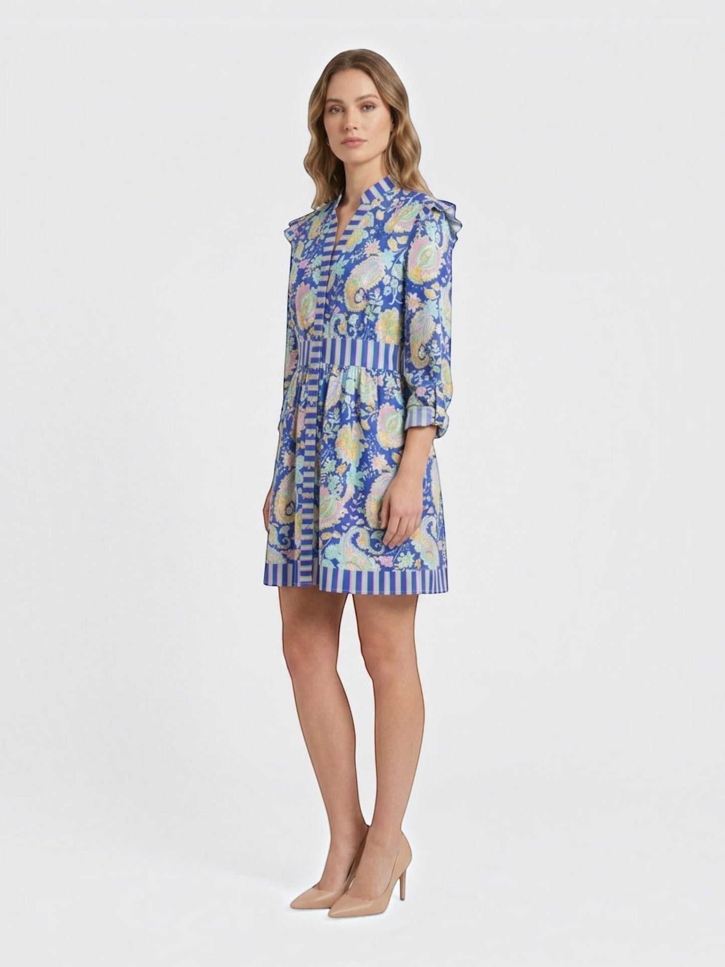 Catherine Martin blue paisley print mini dress with ruffled shoulders, button-front, and striped trim on a model