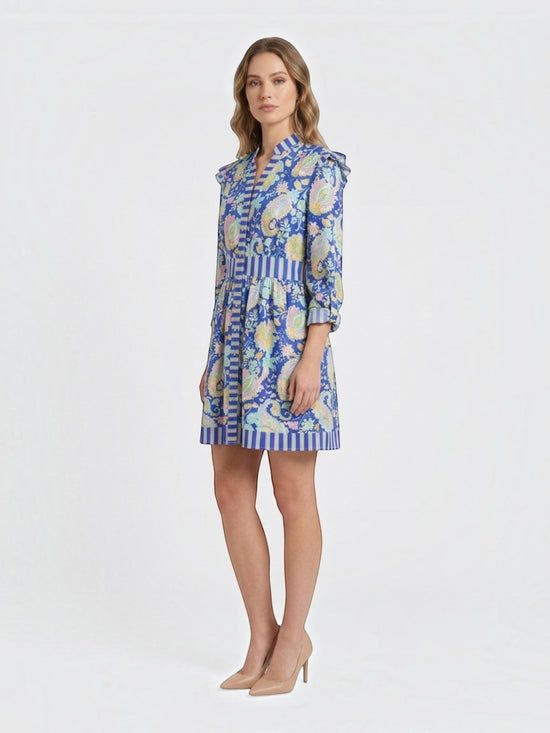 Catherine Martin blue paisley print mini dress with ruffled shoulders, button-front, and striped trim on a model