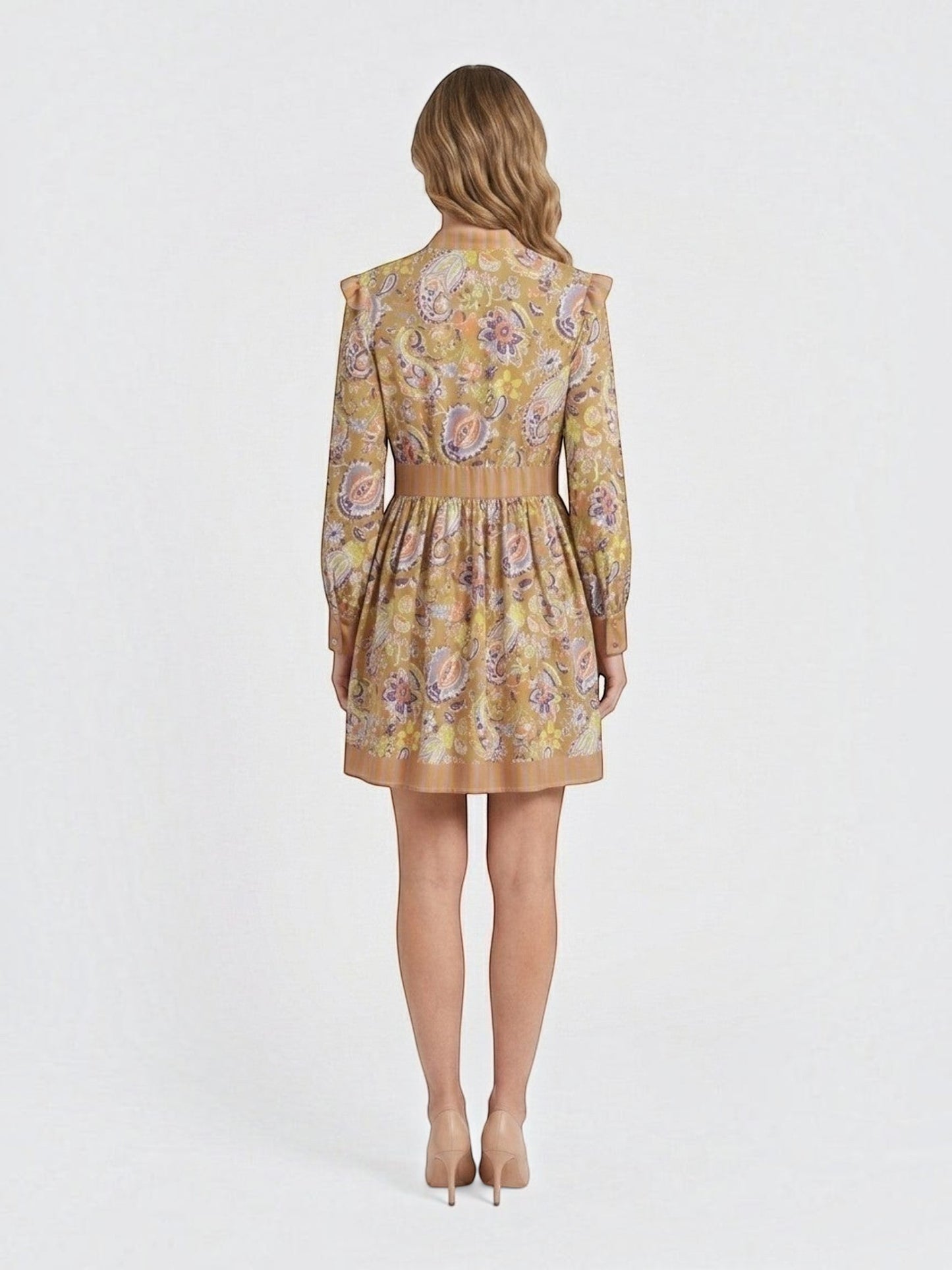 Back view of a Catherine Martin paisley print mini dress in mustard yellow with ruffled shoulders and striped trim.
