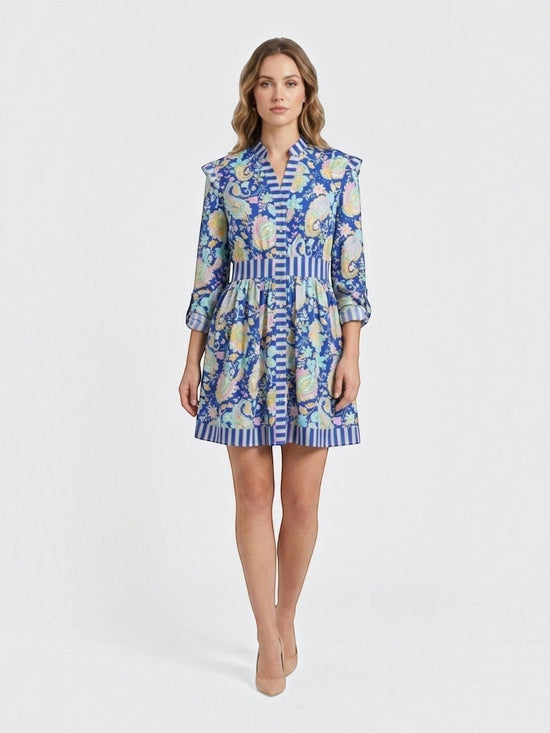 Catherine Martin paisley print mini dress in blue polyester with ruffled shoulders, button front, and striped trim.