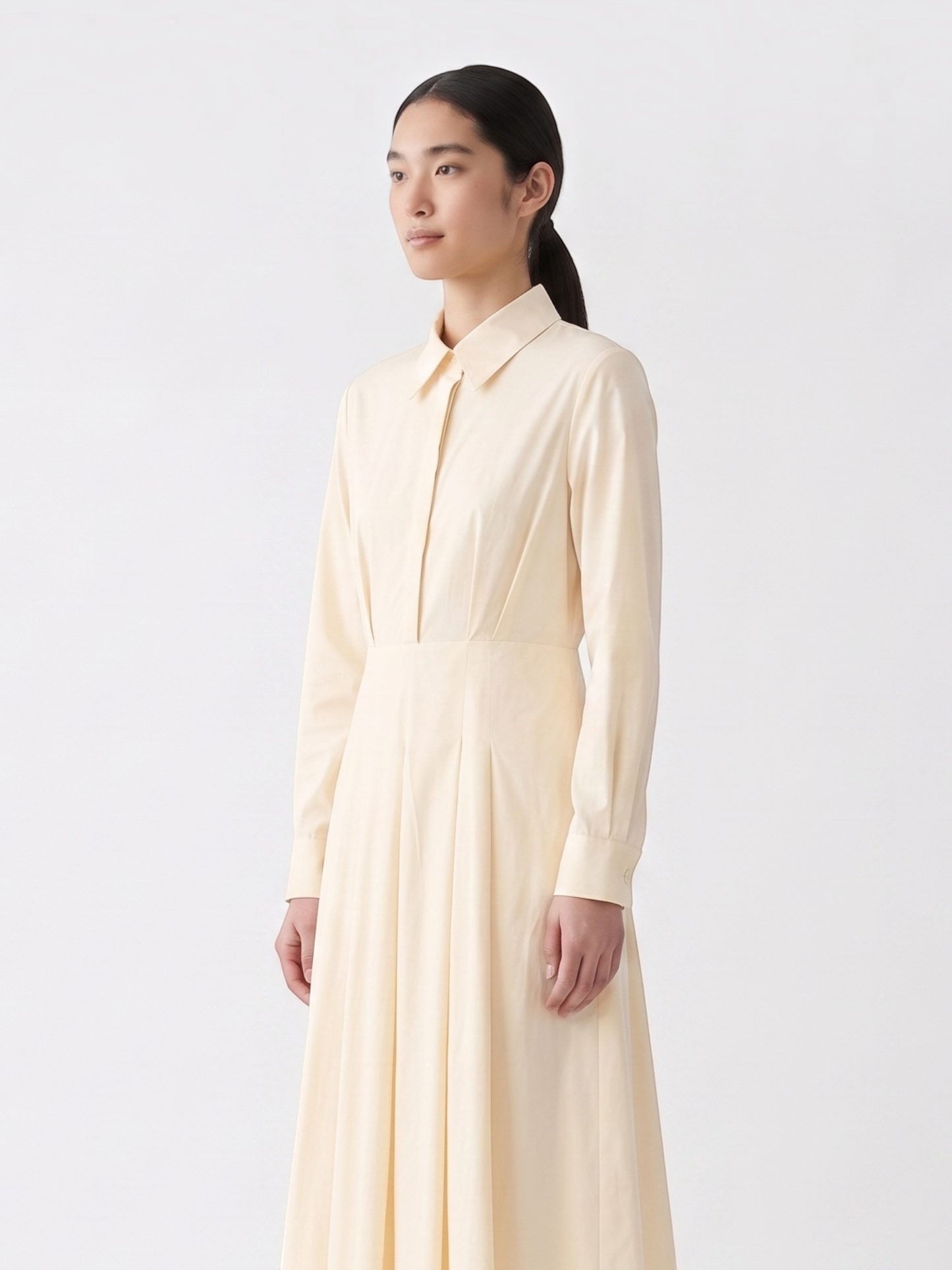 Catherine Martin pale yellow cotton midi shirt dress with a pointed collar, long sleeves, and a pleated skirt.