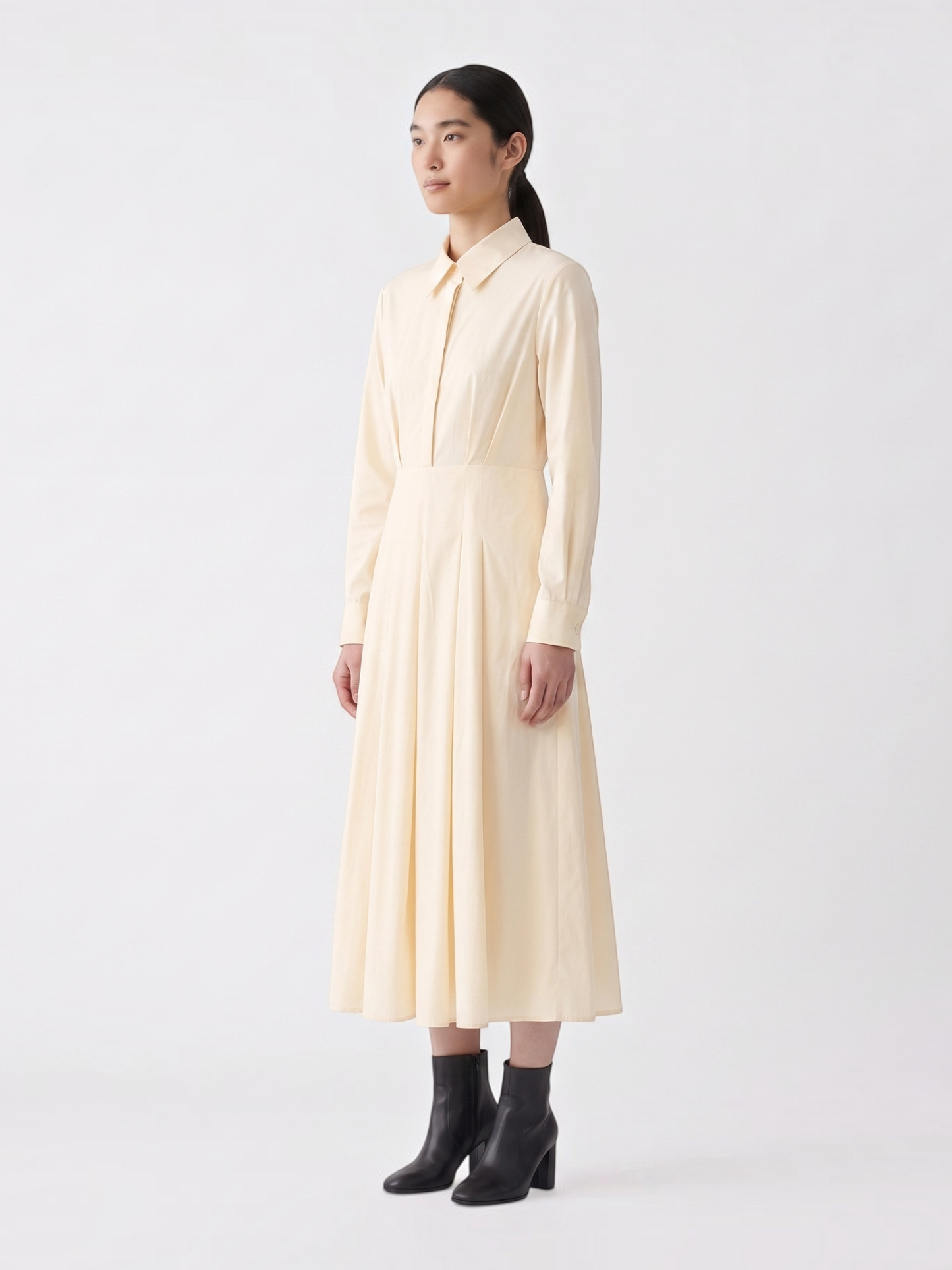 Catherine Martin pale yellow cotton midi shirt dress with a pointed collar, pleated skirt, and long sleeves.