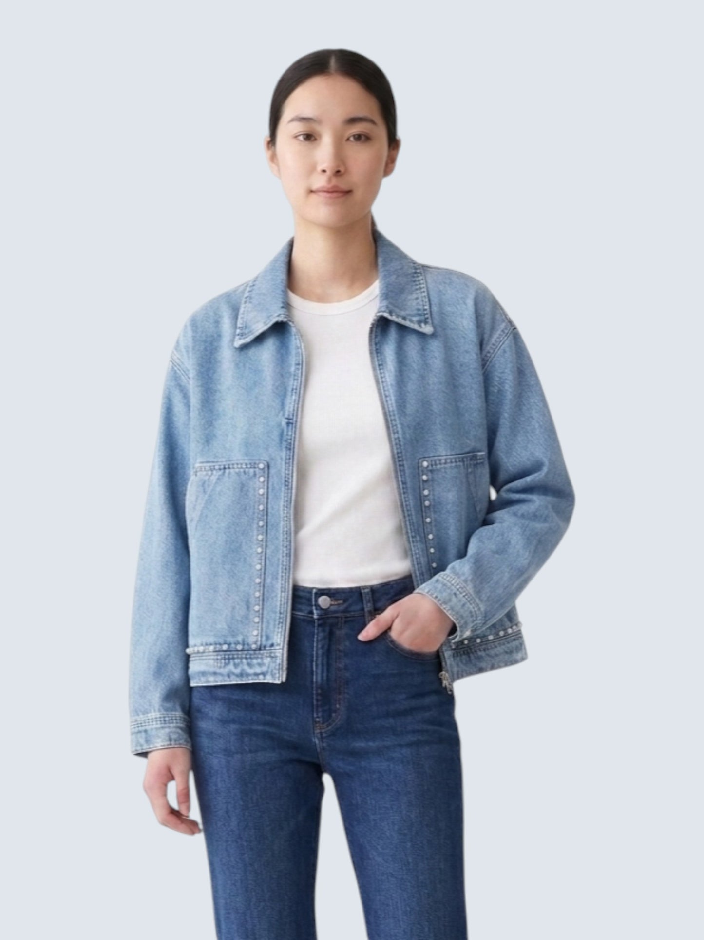 Catherine Martin light-wash denim jacket with pearl stud detailing, collared neckline, and front metal zipper.