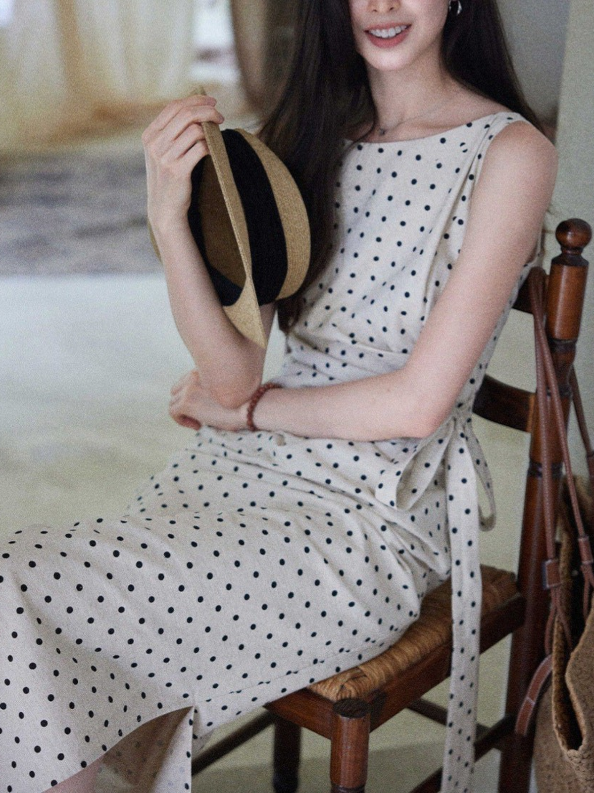 Catherine Martin sleeveless midi dress in beige linen-cotton with black polka dots, side tie, and boat neckline.