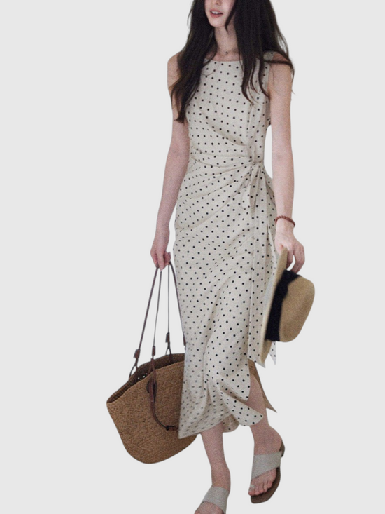 Catherine Martin beige linen-cotton midi dress with black polka dots, boat neckline, and side tie waist detail.