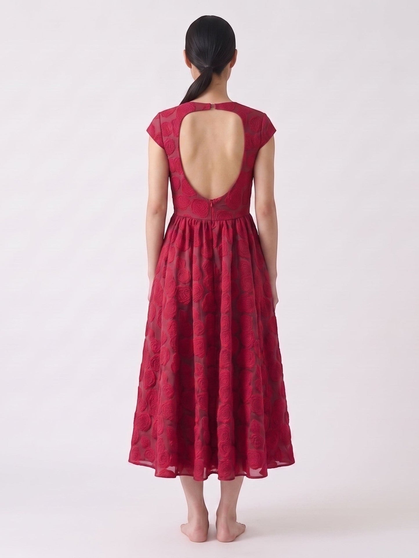 Catherine Martin red rose jacquard mid-length dress with a backless design and short sleeves on a model