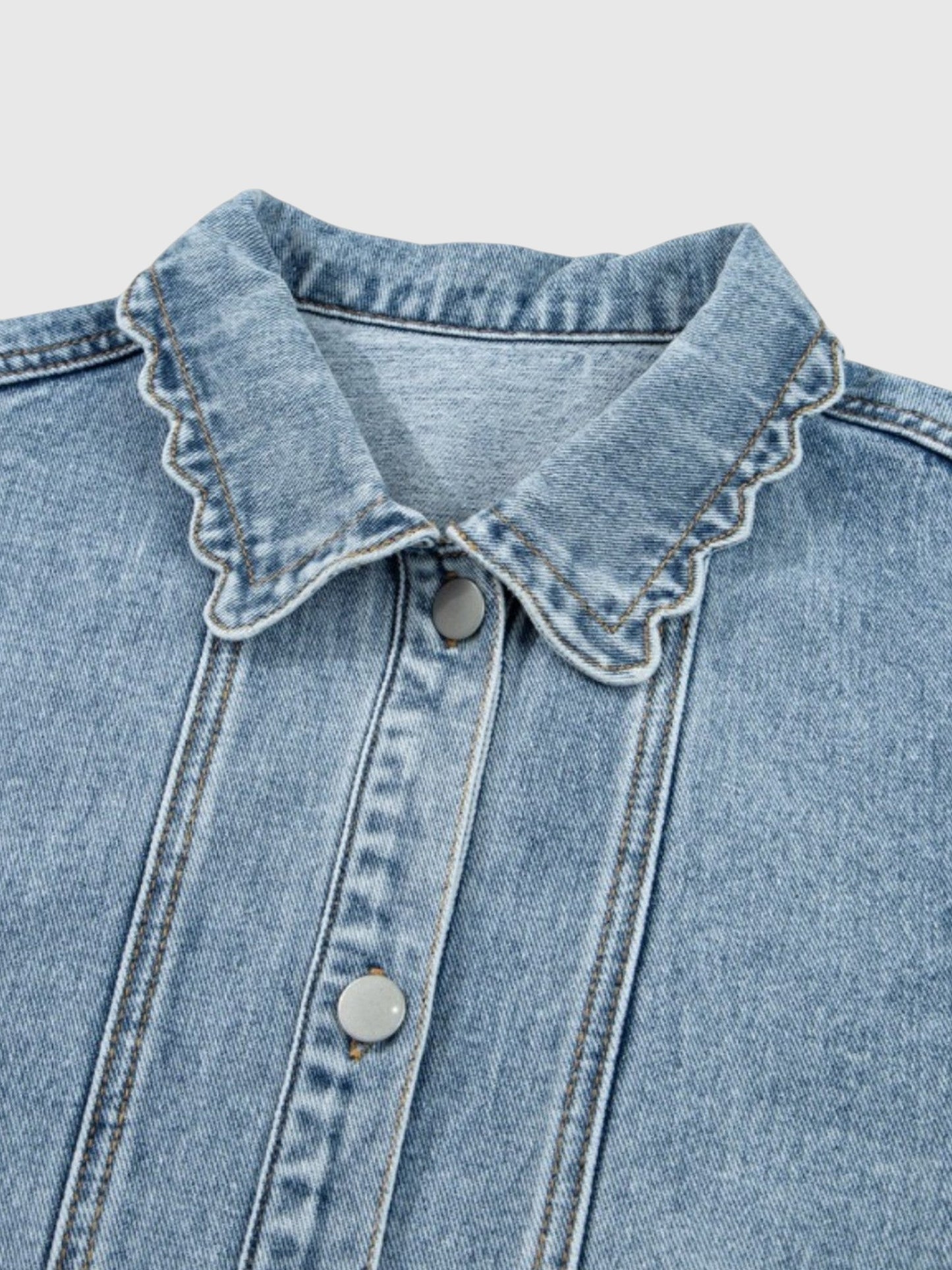 Catherine Martin light-wash denim jacket featuring a collared neckline with delicate scalloped trim and snap buttons.