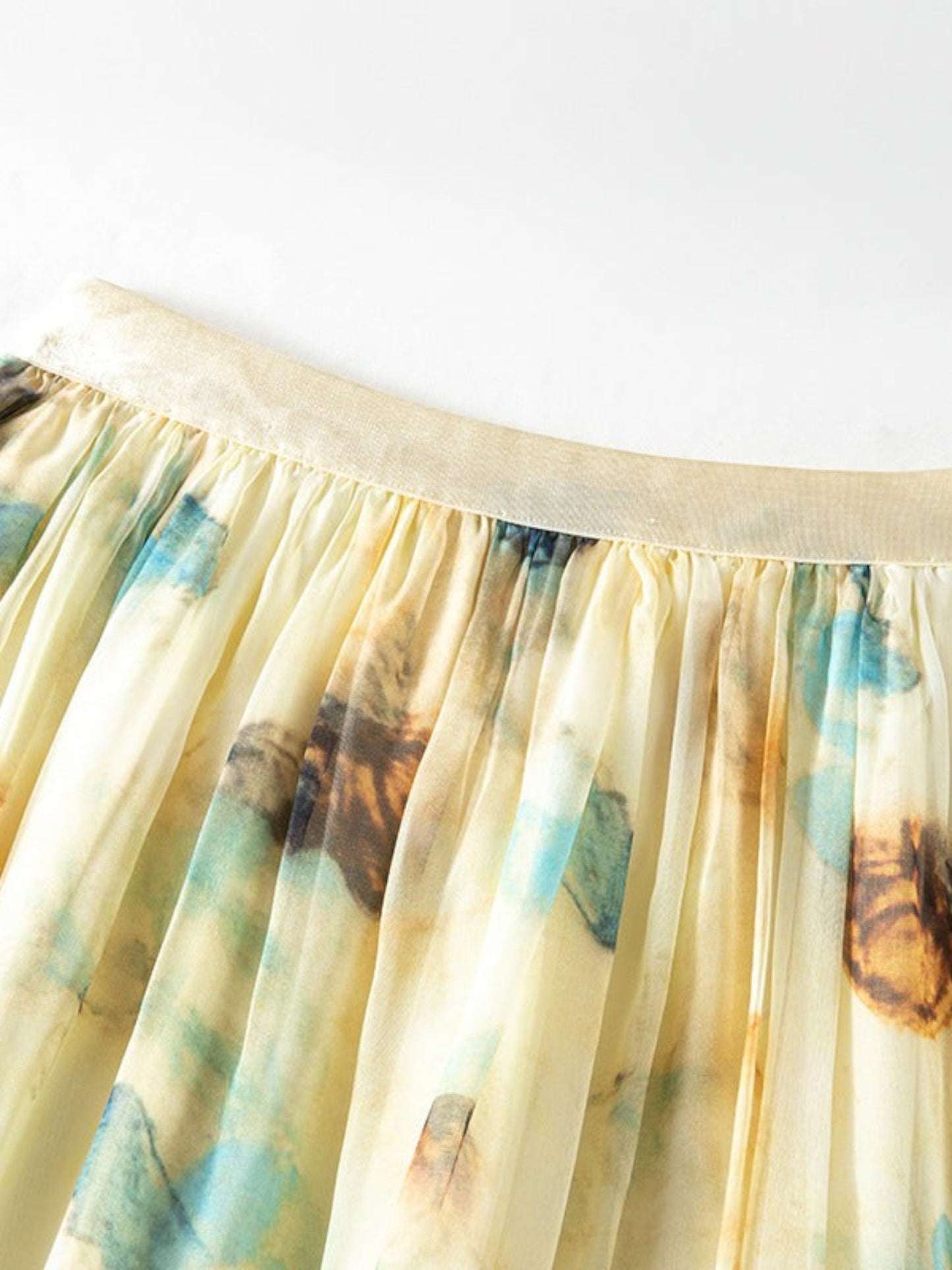Catherine Martin pleated midi skirt in silk chiffon with a blue and gold watercolour print on a pale yellow base.