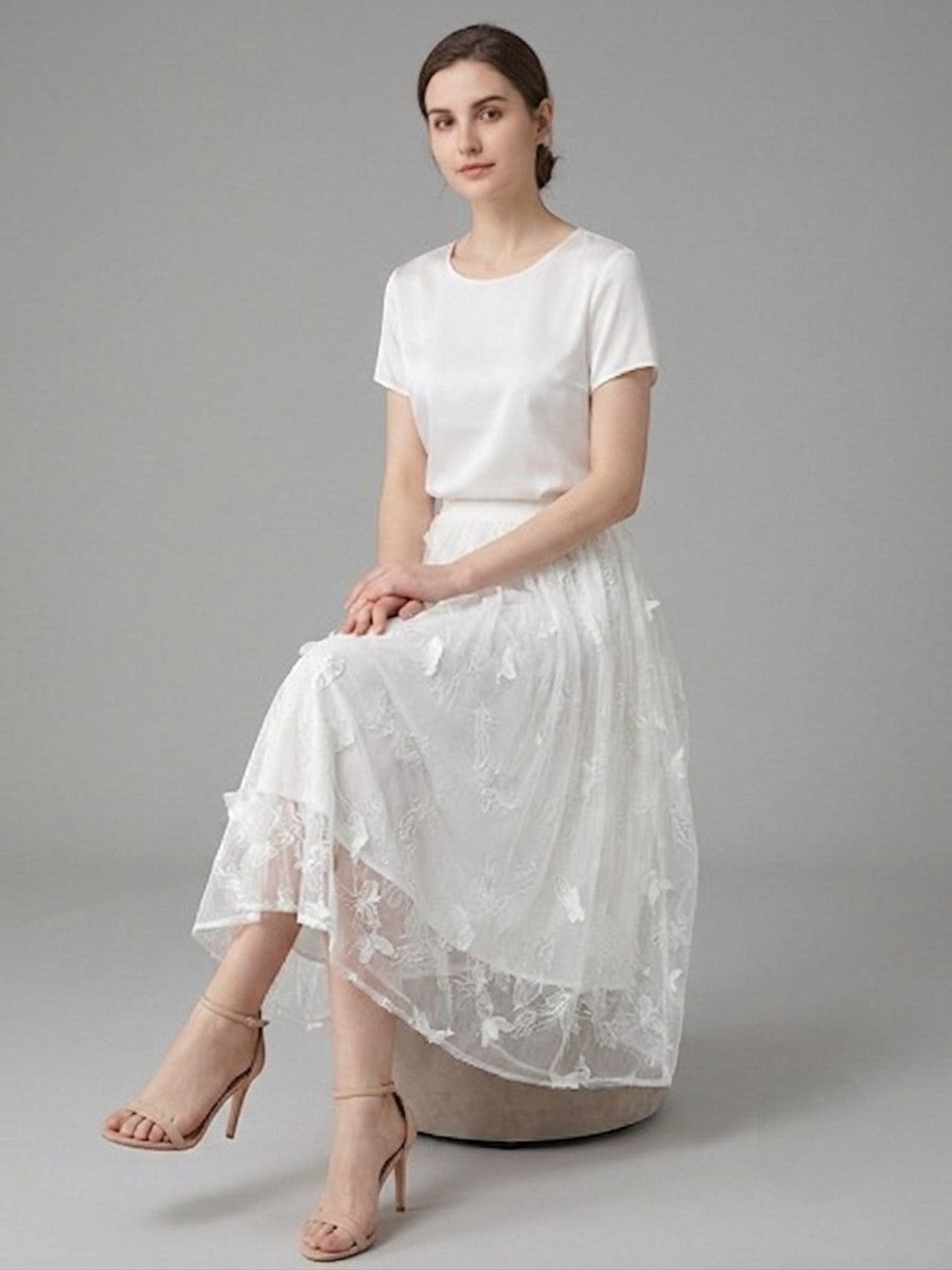 Catherine Martin white silk chiffon midi skirt with butterfly and floral embroidery worn by a seated model