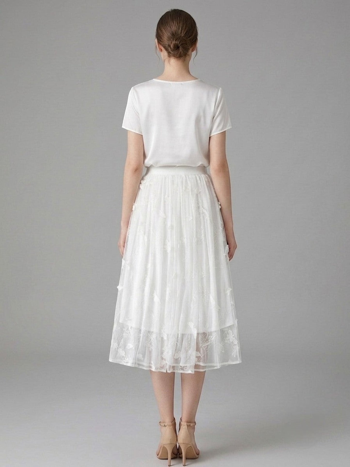 Catherine Martin white silk chiffon midi skirt with floral and butterfly embroidery, shown from the back on a model.