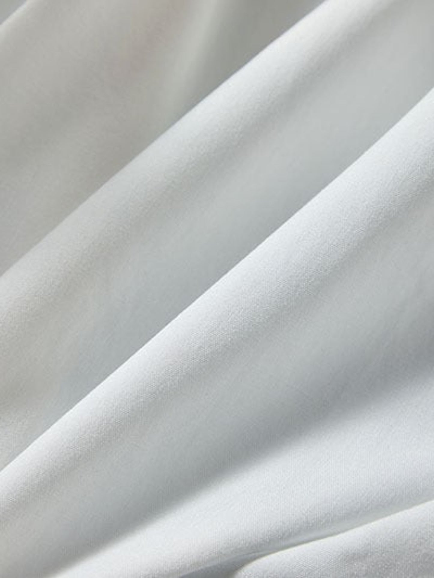 Catherine Martin white silk fabric detail showing the soft texture and draped folds of the midi dress material
