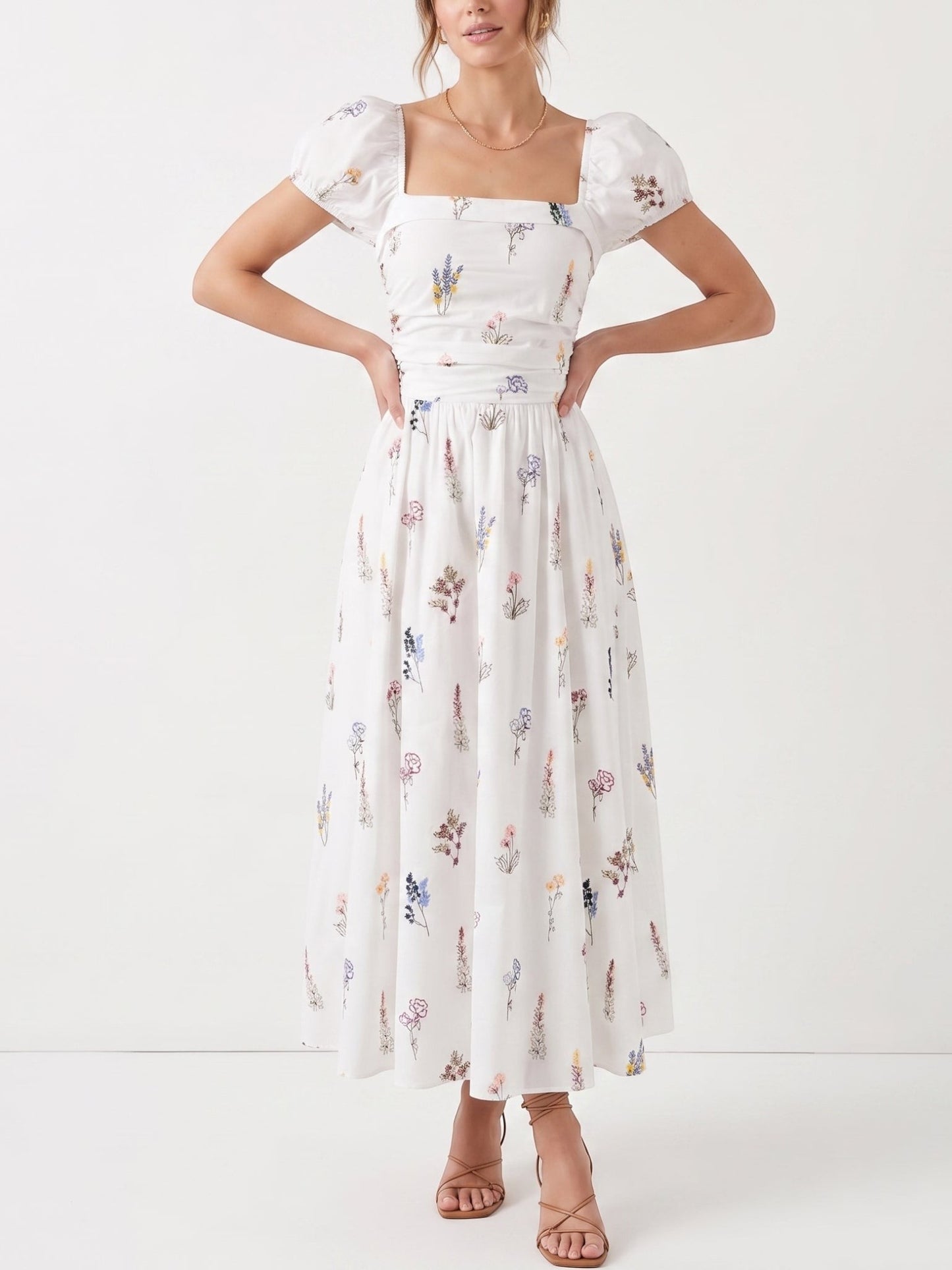 Catherine Martin white cotton midi dress with wildflower print, square neckline, puff sleeves, and smocked bodice.