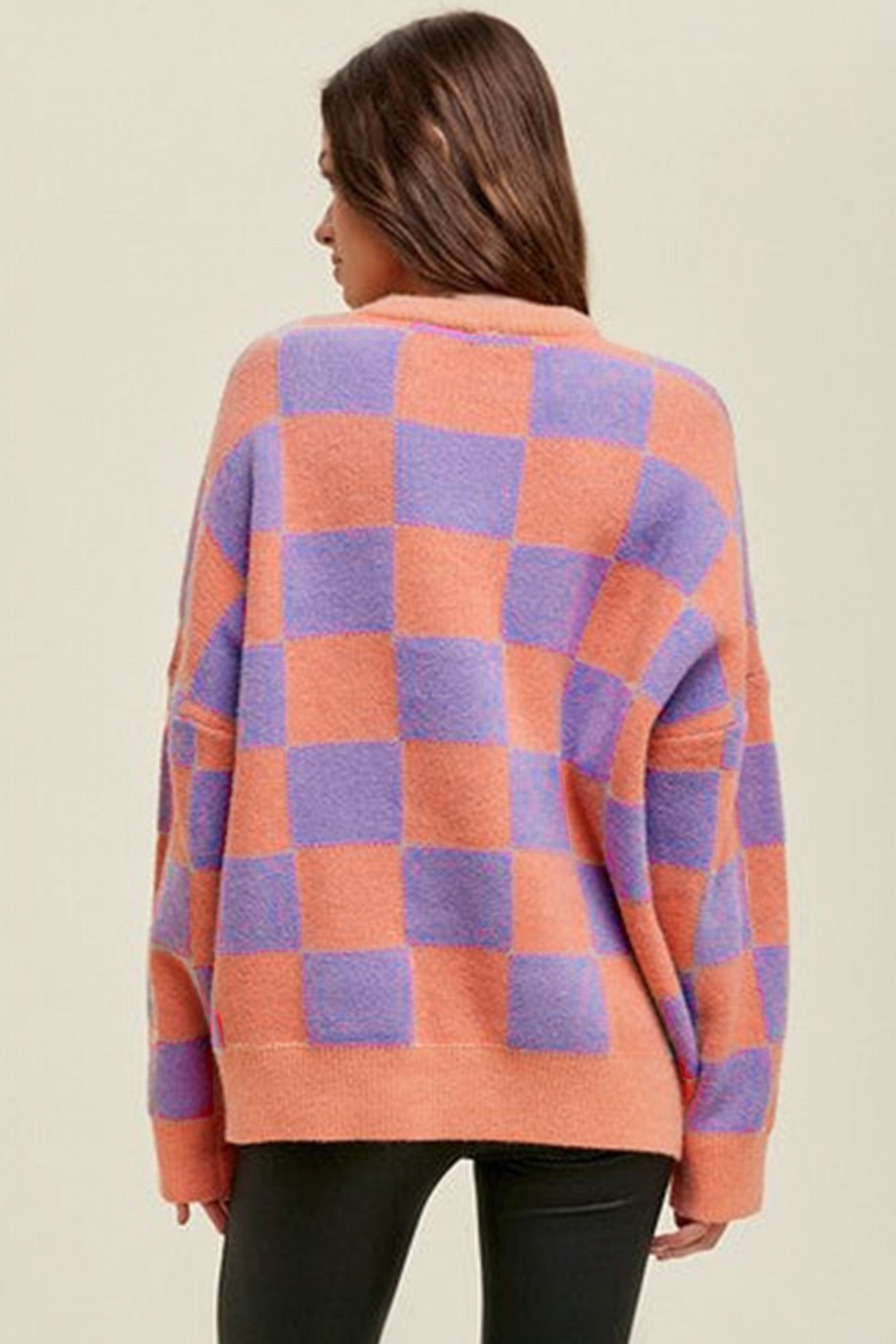 Coral checkerboard crew neck knit sweater back view styled with black leather-look pants