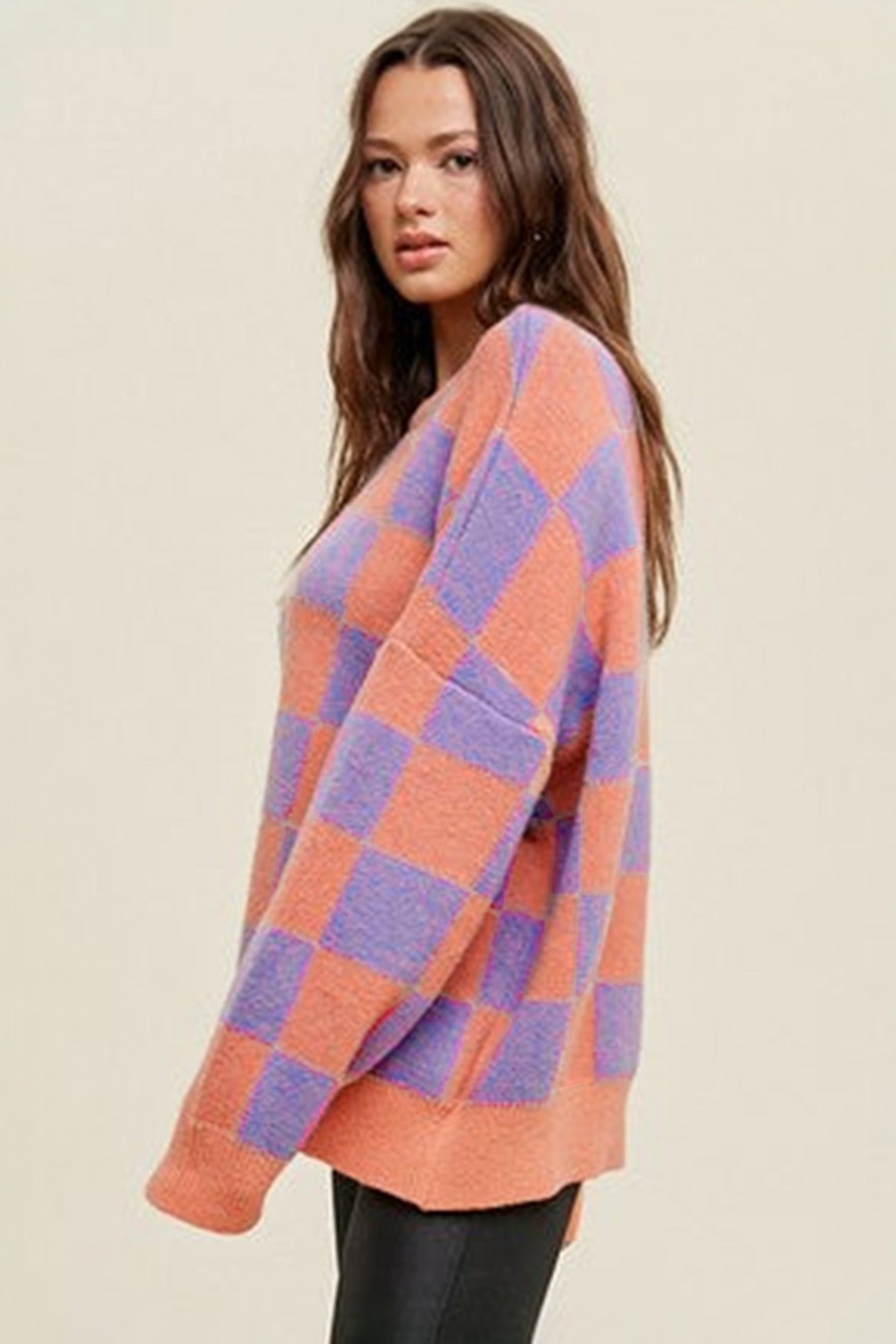 Coral checkerboard crew neck knit sweater side view styled with black leather-look pants