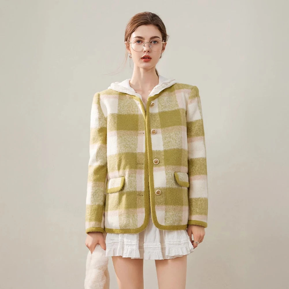 Woman wearing a green and white checkered jacket on a plain background