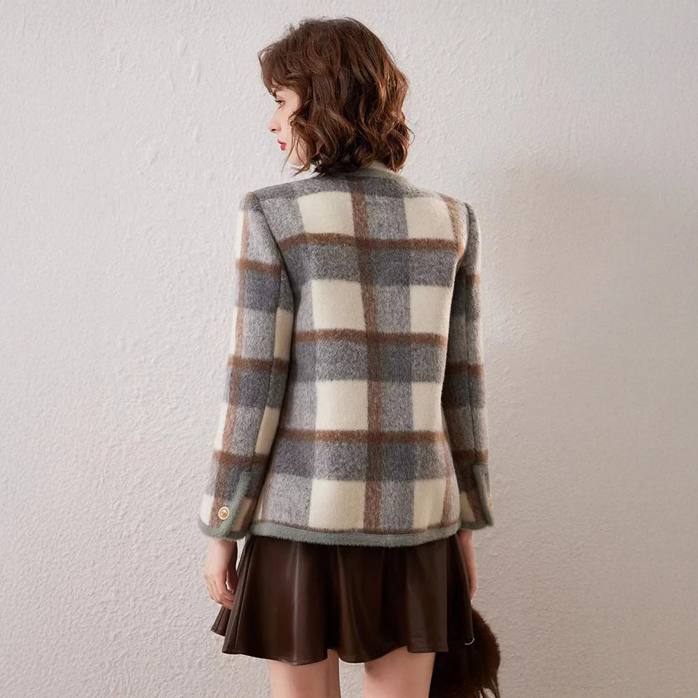 Person wearing a plaid jacket and brown skirt against a plain background