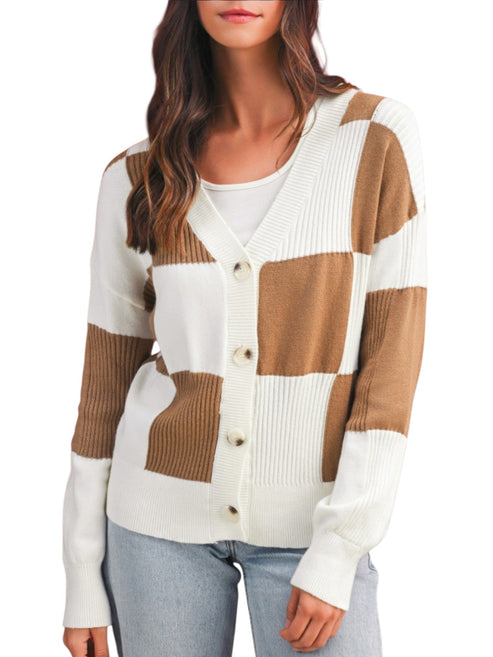 A woman wearing a color-block knit cardigan sweater with white and tan blocks, paired with light blue jeans against a plain white background.