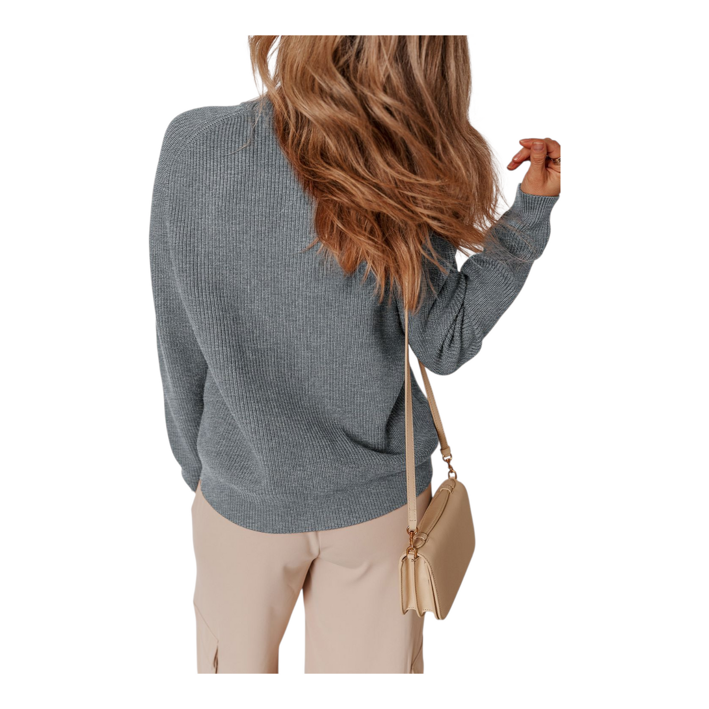 Person wearing a gray sweater and beige pants, holding a beige handbag on a white background