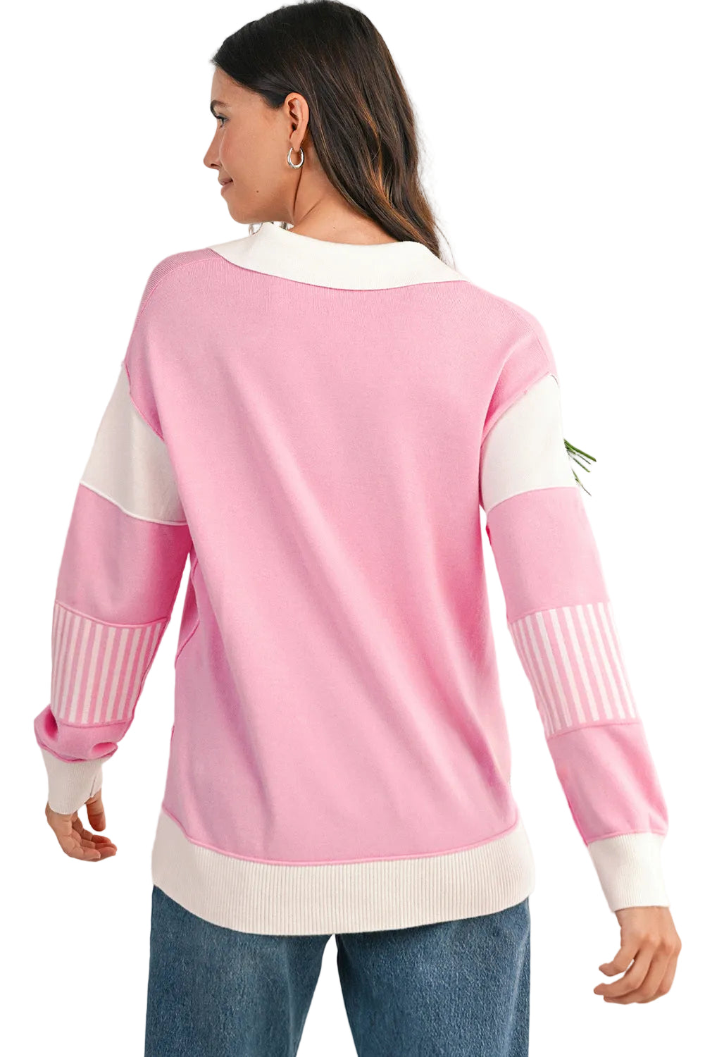 Woman wearing a pink and white sweater with a white background