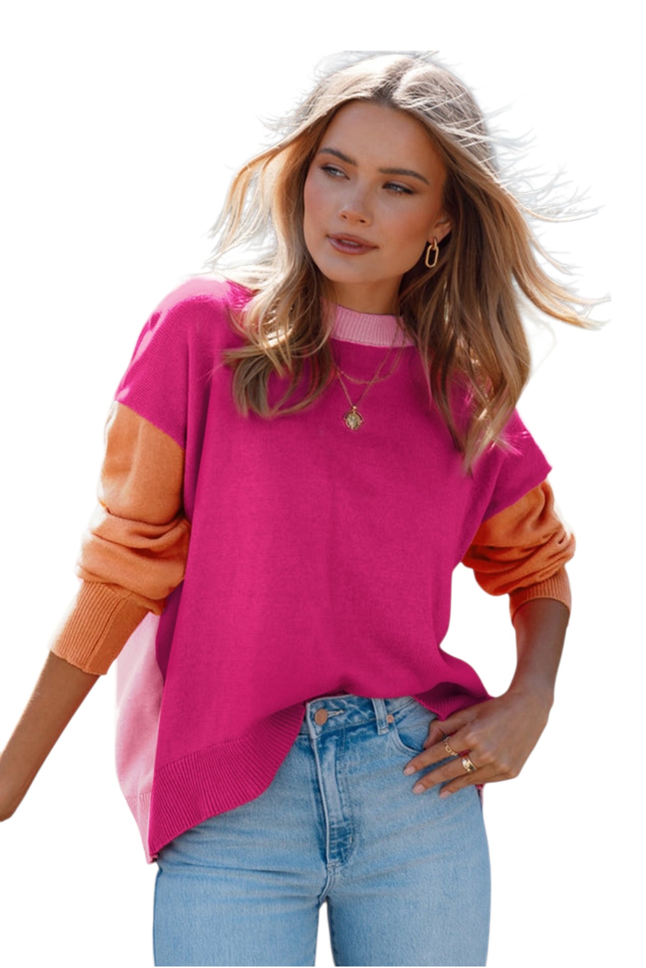A woman wearing an oversized knit sweater with a bold color-block design. The front of the sweater is a vibrant magenta with a light pink crew neckline. She is paired with light-wash denim jeans and gold jewelry.