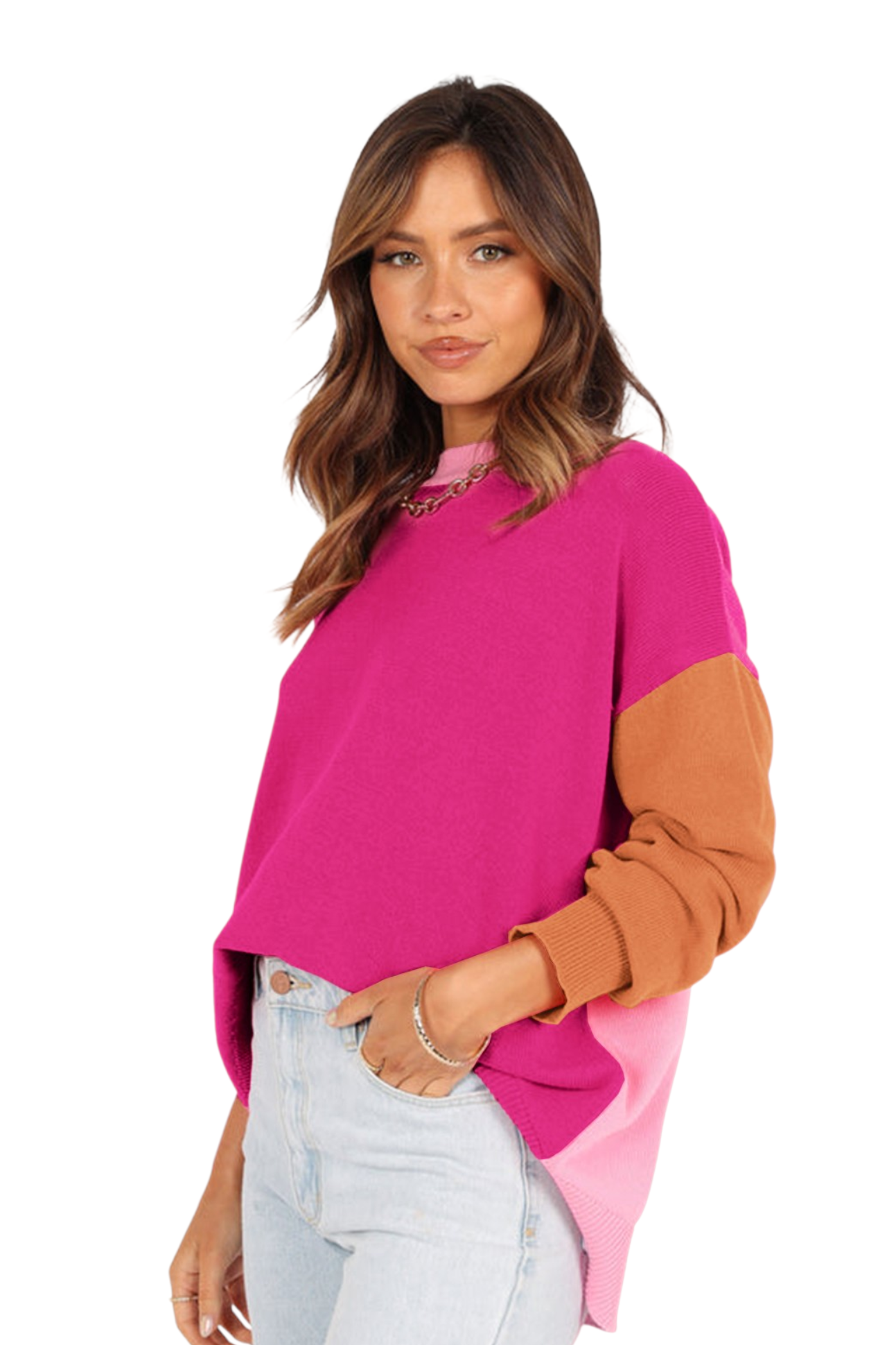 A side profile of the woman showing the contrast between the magenta front and the light pink back panel of the sweater. The sleeves are a warm caramel brown with ribbed cuffs, and the hem features a slight high-low cut.