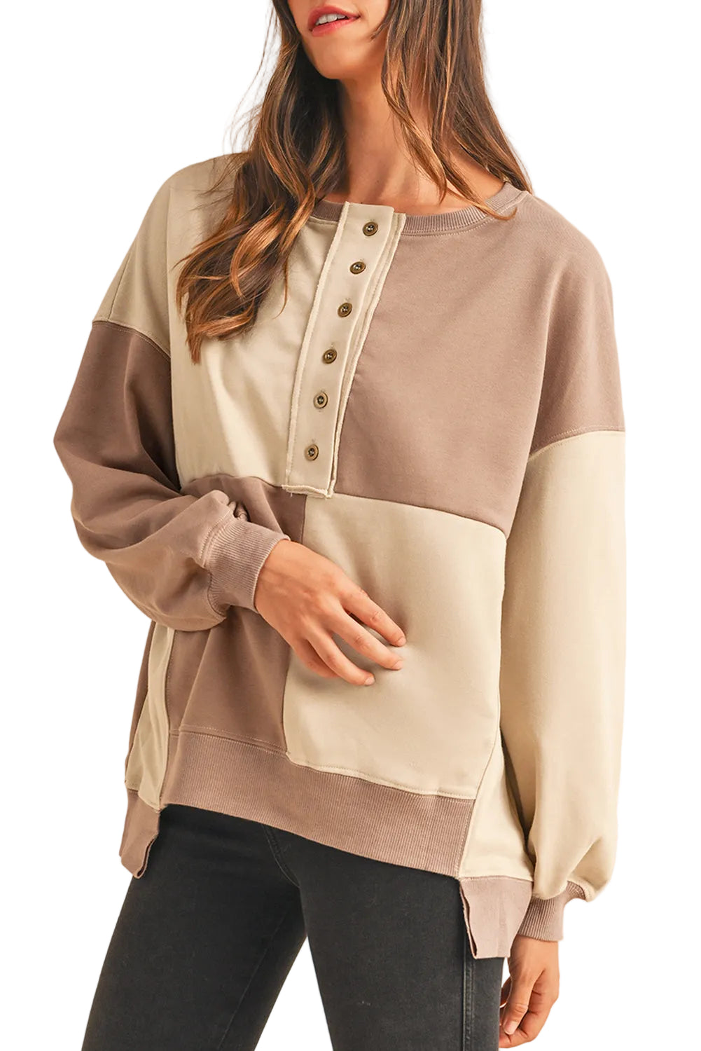 Model styling the cream and taupe neutral version of the patch button sweater, showing the relaxed neck line.