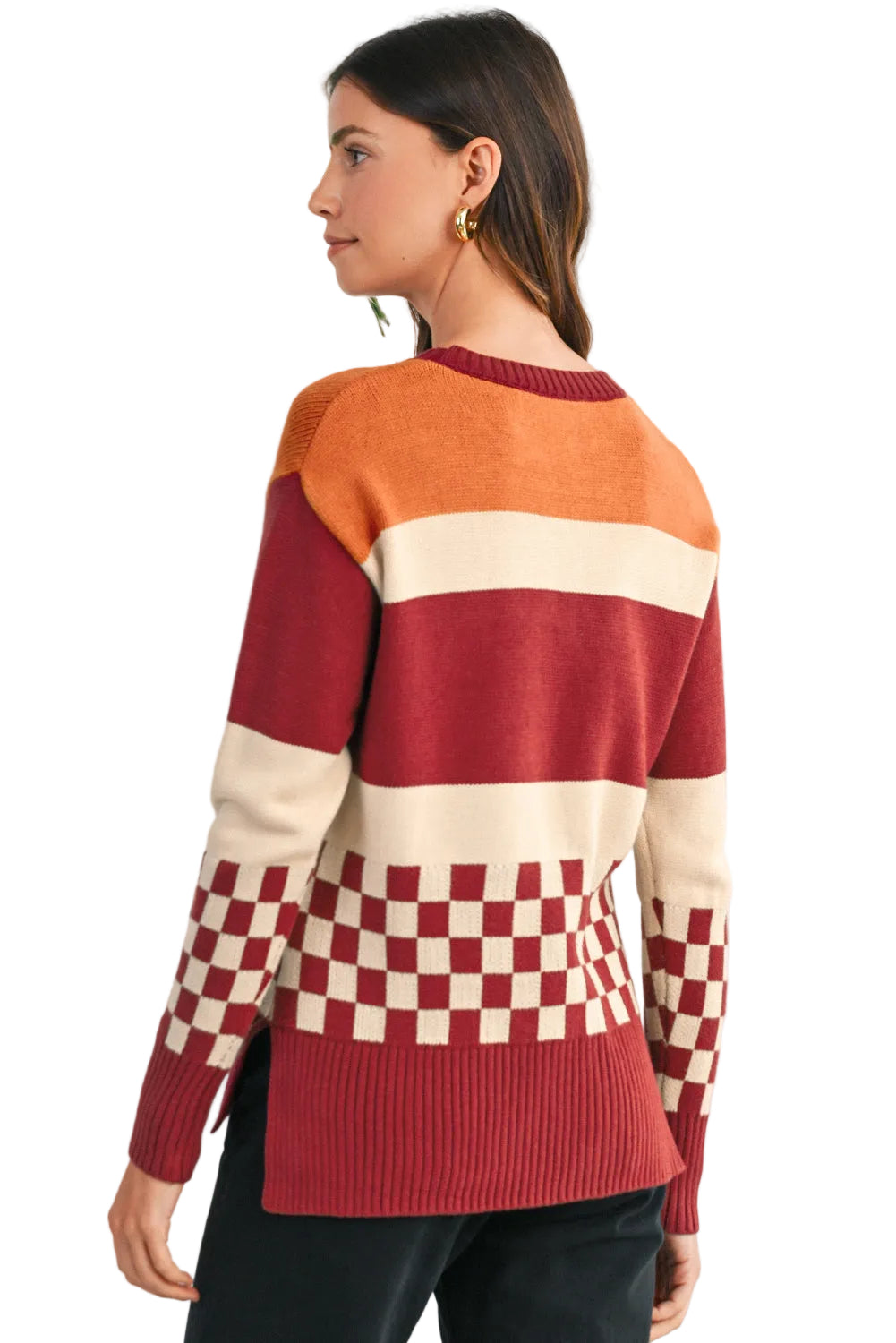 Woman wearing a colorful sweater with a checkered pattern, standing against a light background