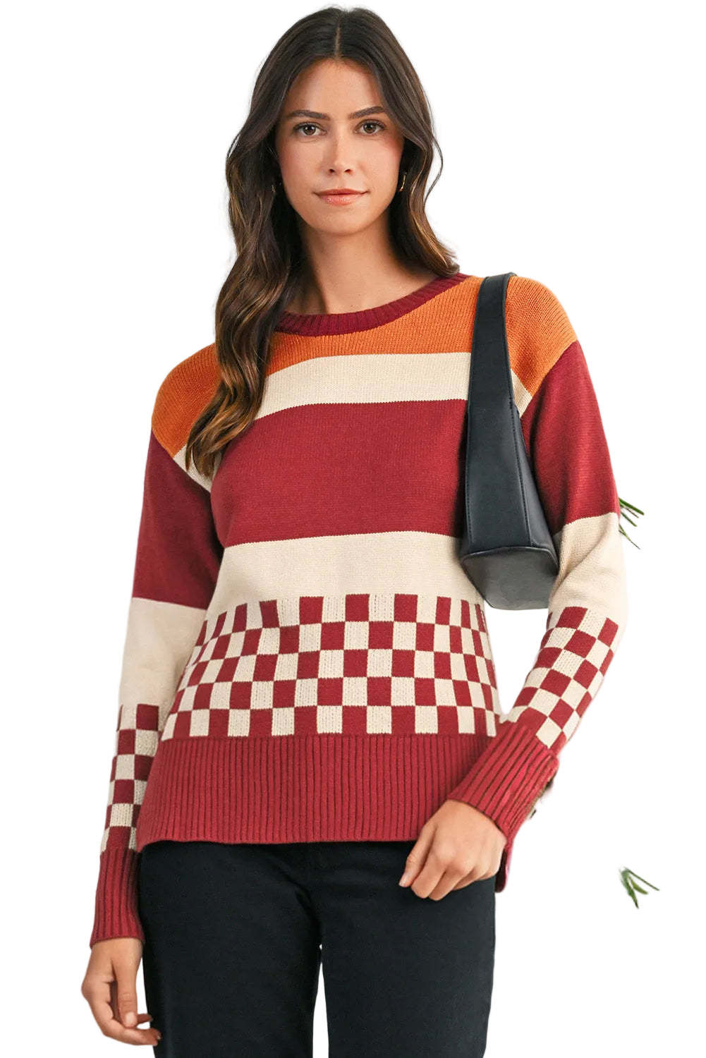 Woman wearing a colorful sweater with a checkered pattern, holding a black bag.