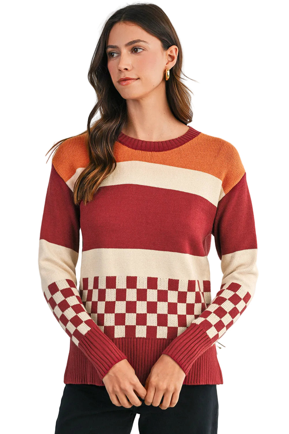 Woman wearing a colorful sweater with a checkered pattern, standing against a light background